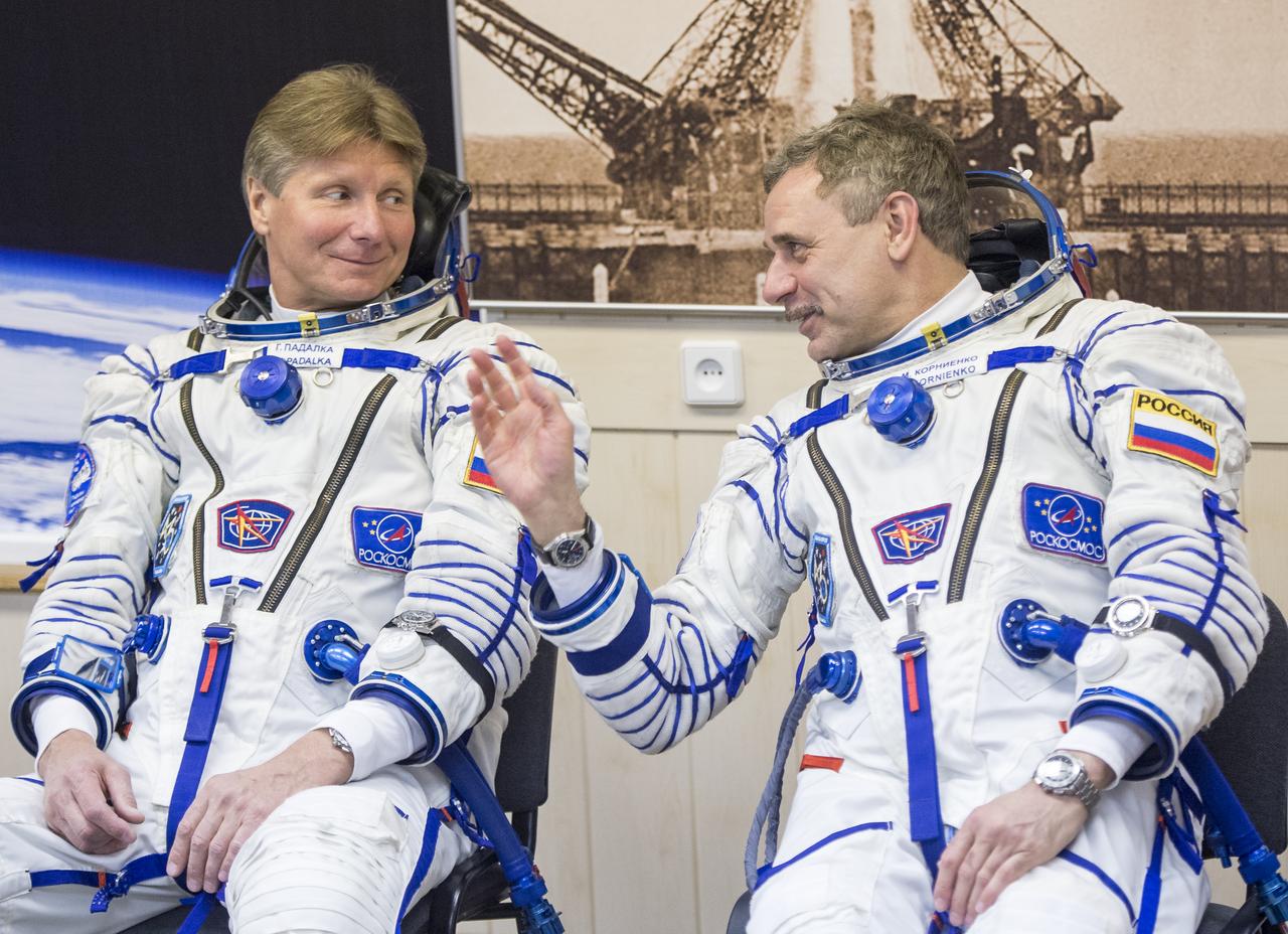 Expedition 43 Russian Cosmonauts Gennady Padalka, left, and Mikhail Kornienko talk as fellow crew member NASA Astronaut Scott Kelly has his Russian sokol suit pressure checked for launch onboard the Soyuz TMA-16M spacecraft to the International Space Station Friday, March 27, 2015 in Baikonor, Kazakhstan. Kelly, Padalka, and Kornienko launched to the ISS from the Baikonur Cosmodrome in Kazakhstan March 28, Kazakh time (March 27 Eastern time.) As the one-year crew, Kelly and Kornienko will return to Earth on Soyuz TMA-18M in March 2016.  Photo Credit: ((NASA/Bill Ingalls)