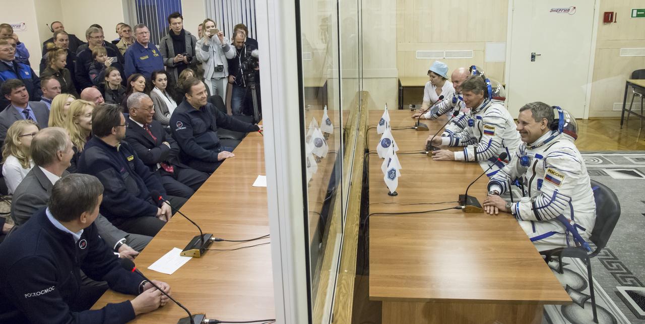 Expedition 43 NASA Astronaut Scott Kelly, Russian Cosmonauts Gennady Padalka, and Mikhail Kornienko of the Russian Federal Space Agency (Roscosmos) talk to NASA Administrator Charles Bolden, left center, and Head of Russian Federal Space Agency (Roscosmos) Igor Komarov, right, from behind glass before departing for their launch onboard the Soyuz TMA-16M spacecraft to the International Space Station Friday, March 27, 2015 in Baikonor, Kazakhstan. Kelly, Padalka, and Kornienko launched to the ISS from the Baikonur Cosmodrome in Kazakhstan March 28, Kazakh time (March 27 Eastern time.) As the one-year crew, Kelly and Kornienko will return to Earth on Soyuz TMA-18M in March 2016. Photo Credit: (NASA/Victor Zelentsov)