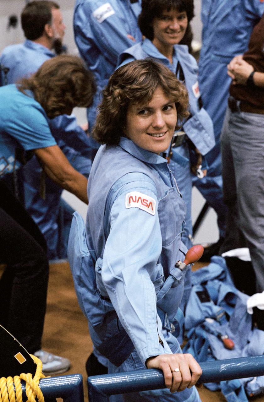 41D-3188 (2 September 1984) --- Astronaut Kathryn D. Sullivan, 41-G mission specialist, joins with other members of the seven-person crew prior to a training session in the Shuttle mockup and integration laboratory at the Johnson Space Center.  Dr. Sullivan will be the first American woman to perform an extravehicular activity (EVA) in space when she joins Astronaut David C. Leestma for some outside-the-Challenger duty on October 9. The mission is scheduled for an October 5, 1984 launch.