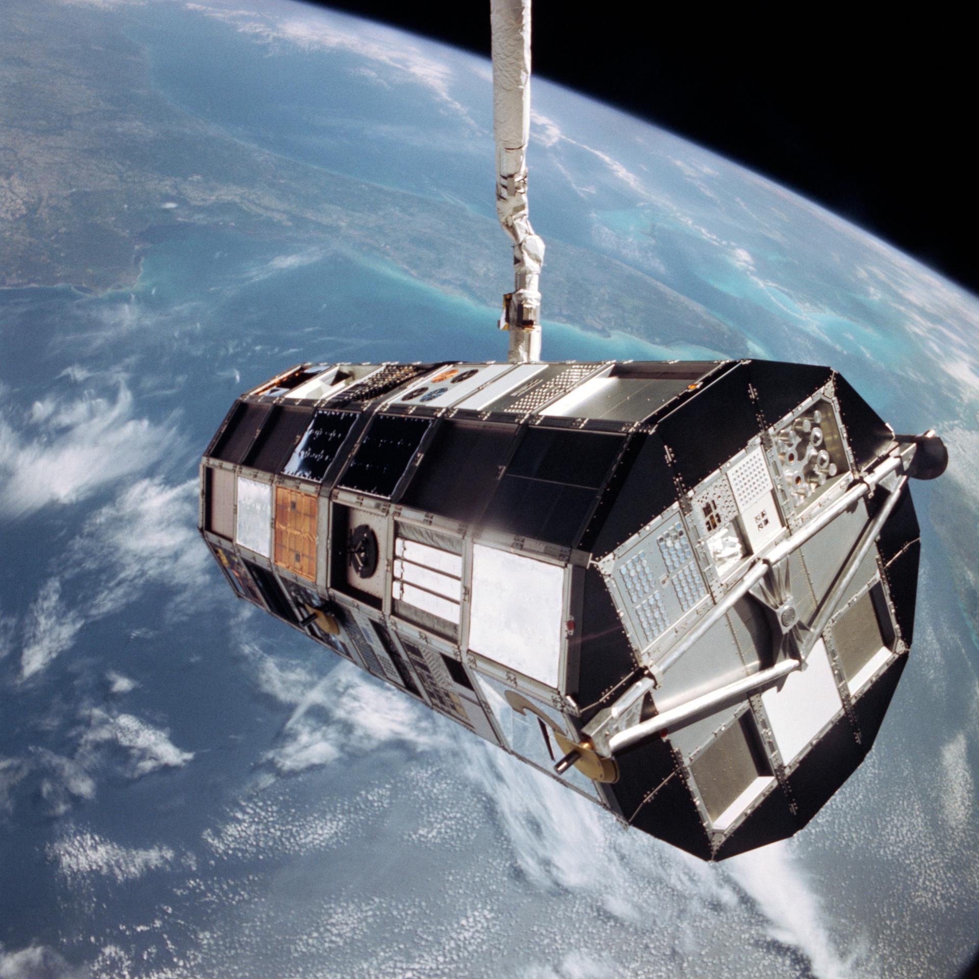 The Shuttle's arm suspends the giant Long Duration Exposure Facility (LDEF) high above the Gulf of Mexico prior to releasing it into space.