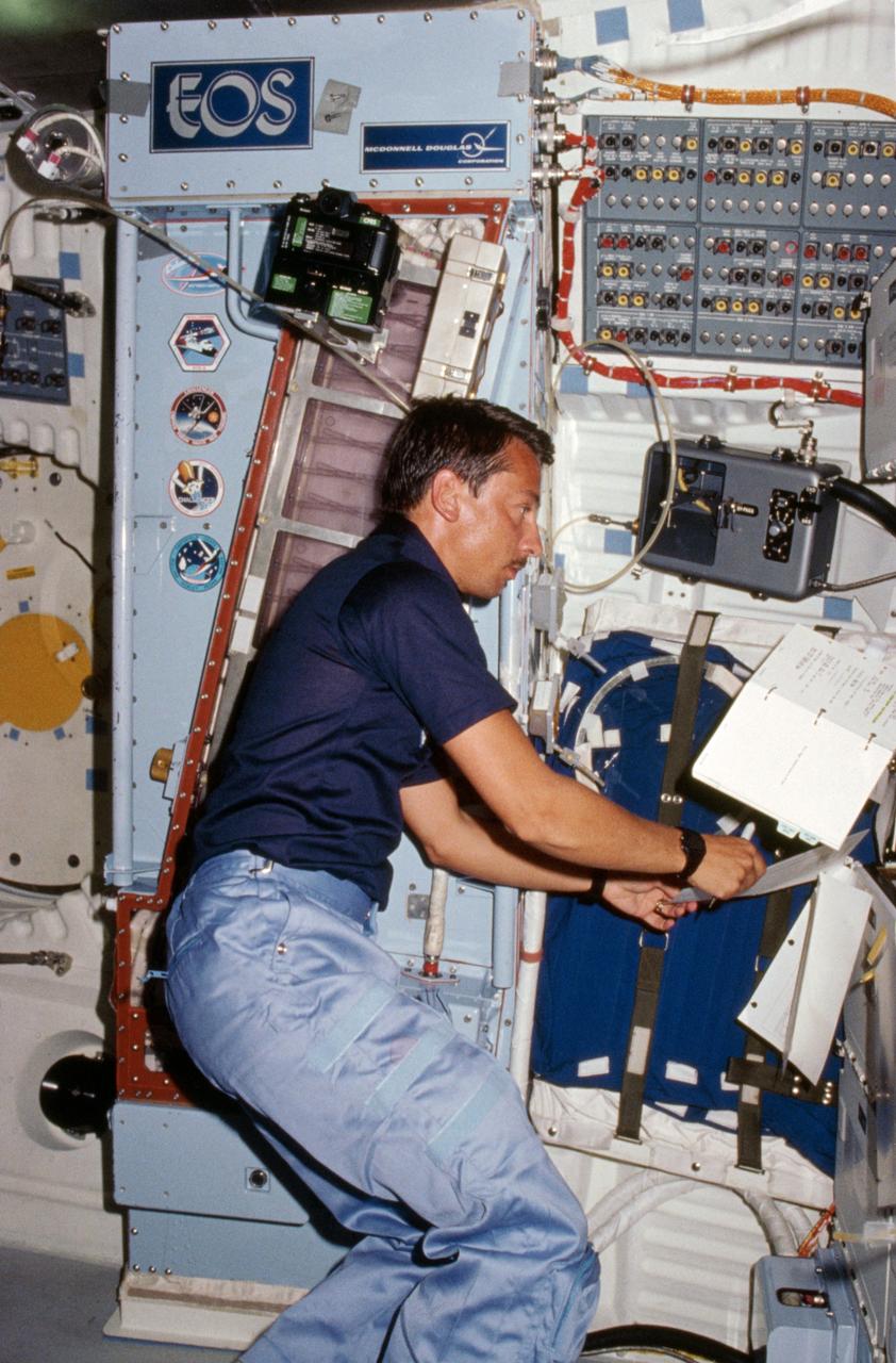 41D-06-013 (6 Sept 1984) --- Payload specialist Charles Walker works with the continuous flow electrophoresis systems (CFES) experiment, located in the middeck.