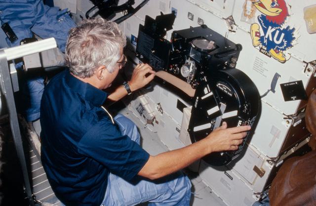 NASA image: View of Crew Commander Henry Hartsfield Jr. loading film into IMAX camera