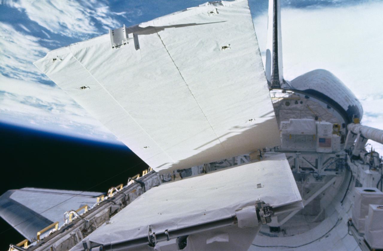View of the SIR-B antenna being deployed during STS 41-G. The Challenger's payload bay is open and the remote manipulator system (RMS) arm is in the stowed position at the right of the view.