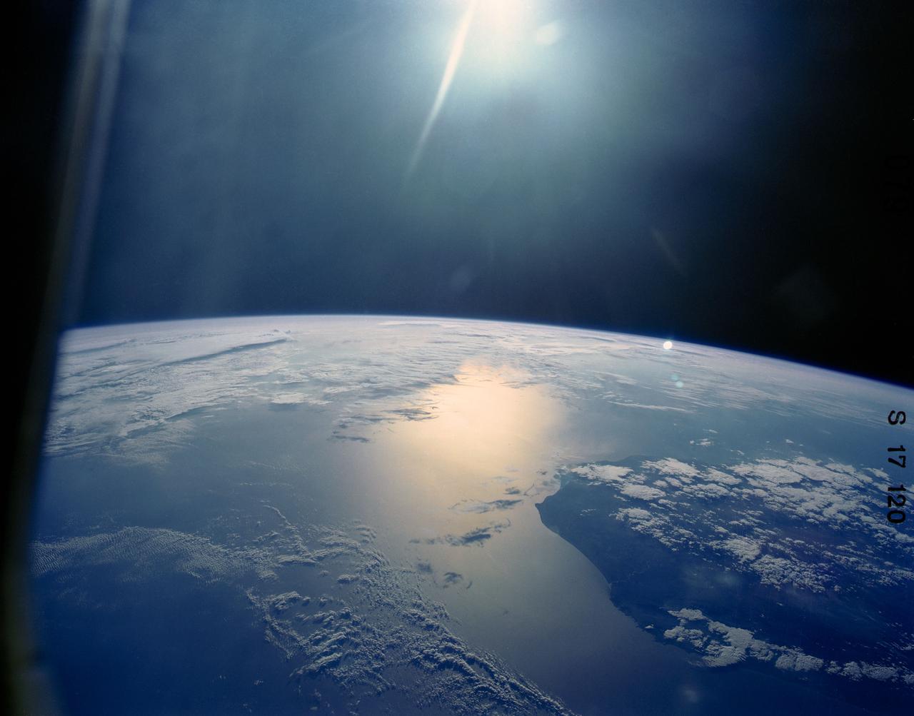 41G-120-079 (5-13 Oct 1984) --- This oblique view, photographed from the Space Shuttle Challenger, shows the south tip of the island of Madagascar.  Sunglint reflects on the surface of the Mozambique Channel.  The crew consisted of astronauts Robert L. Crippen, commander; Jon A. McBride, pilot; mission specialist's Kathryn D. Sullivan, Sally K. Ride, and David D. Leestma; Canadian astronaut Marc Garneau; and Paul D. Scully-Power, payload specialist.        EDITOR'S NOTE: The STS-41G mission had the first American female EVA (Sullivan); first seven-person crew; first orbital fuel transfer; and the first Canadian (Garneau).