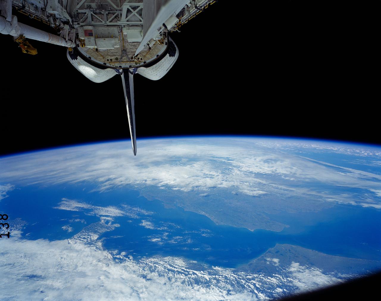 41G-121-138 (5-13 Oct 1984) --- A view of the Earth's horizon featuring France and England.  The Strait of Dover and the English channel are visible behind the tail (vertical stabilizer) of Challenger.  The remote manipulator system (RMS arm rests in its "stow" position at upper left corner.
