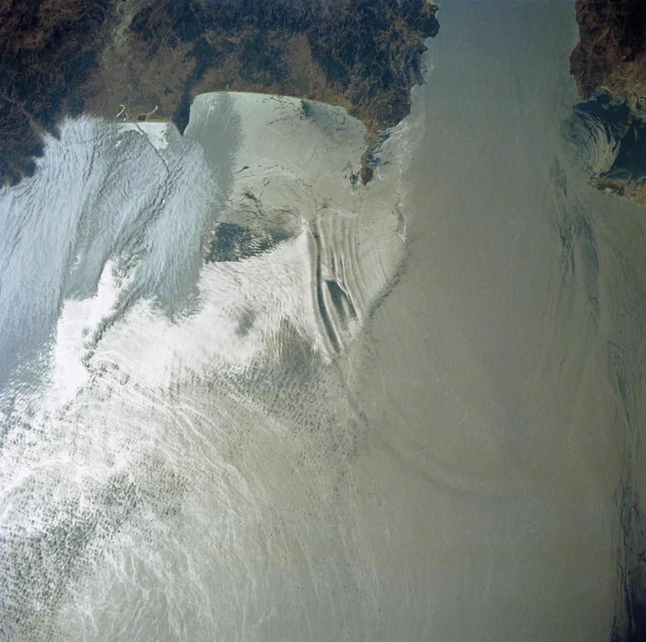 41G-34-098 (5-13 Oct 1984) --- Strait of Gibraltar and western Mediterranean photographed sunglint.  Sun reflection on water delineates surface texture, which corresponds to the ocean's dynamics.  The  large group of waves connecting Gibraltar with the Moroccan coast is the response of the ocean to a tidal pulse moving into the Mediterranean.  The low level wing shear line extending out from the Moroccan coastline into the Mediterranean for approximately 40 miles is the southern extremity of the wind funneling through the strait.  This  is the first high resolution photograph ever taken of this phenomenon permitting detailed delineation of individual waves which comprise the wave packet.