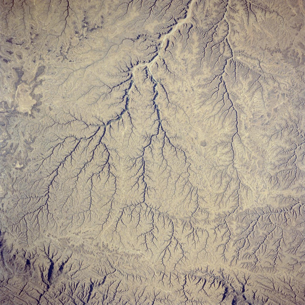 41G-36-036 (5-13 Oct 1984) --- The deeply etched patterns of intermittent streams in the Hadhramaut Plateau of south Yemen.  These stream beds, which now rarely carry water, are deeply entrenched, owing to the geologically recent uplift of the plateau.  nonetheless, a very distinct watercourse appears along the top and bottom edges of the photograph.  In the photograph's upper portion, available water will flow into the vast emptiness of the Rub al Khali (Empty Quarter).  In the lower portion, water will flow to the Gulf of Aden.