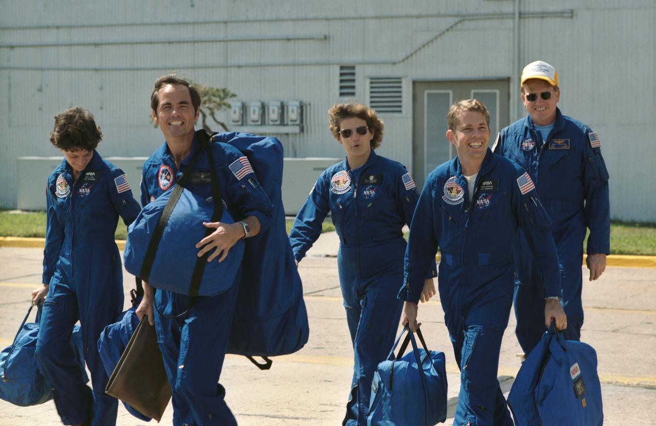 41G-90029 / S17-90029 (2 Oct 1984) --- These five astronauts prepare to board T-38 jet aircraft for a trip to Florida where they will begin preparations for a trip into space aboard the Challenger later this week.  Astronaut Robert L. Crippen, left, leads the way.  The crew commander is followed by (l.-r.) Sally K. Ride (extreme left edge), Kathryn D. Sullivan, David C. Leestma and Jon A. McBride, McBride is pilot and the others are mission specialists.  Marc Garneau, representing the National Research Council of Canada and Paul D. Scully-Power, a civilian oceanographer with the U.S. Navy, are the payload specialists who will fly to Florida aboard a Gulfstream aircraft.