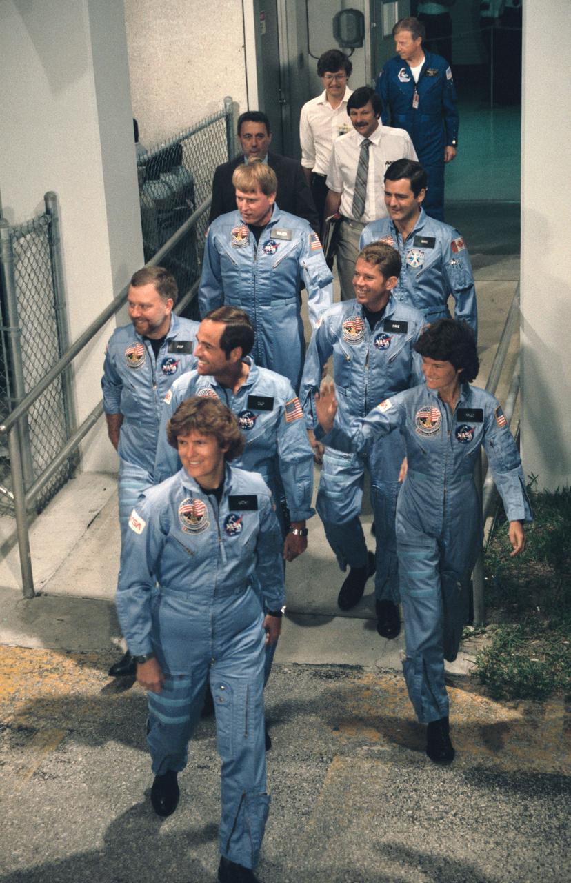 41G-90081 / S17-90081 (5 Oct 1984) --- The seven member crew leaves the Operations and Checkout Building (OCB) to take a van ride to the launch pad.  Leading the way is Kathryn D. Sullivan followed in file by Robert L. Crippen, Paul D. Scully-Power and Jon A. McBride.  On the right side are Sally K. Ride, David C. Leestma and Marc Garneau.  Trailing the crew are George W. S. Abbey, Richard Nygren, Paul Bulver, and Paul J. Weitz.