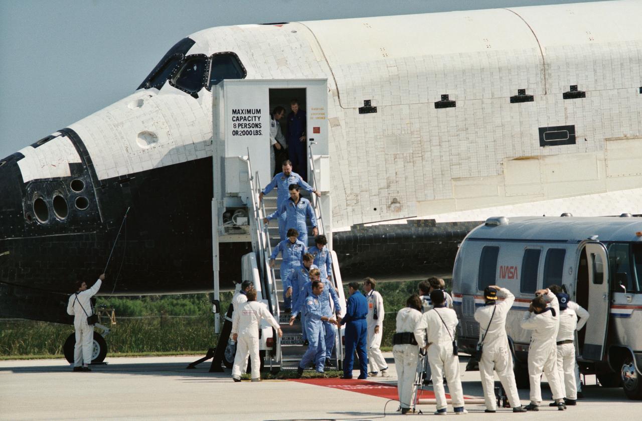 41G-90217 (13 Oct 1984) --- 41-G crew leaves the orbiter after landing at Kennedy Space Center at the end of their mission. Astronaut Robert Crippen shakes hands with George W.S. Abbey, Director of JSC's Flight Crew Operations, while the other crewmembers wait behind him. They are Jon McBride, David Leestma, Sally K. Ride, Kathryn Sullivan, Marc Garneau and Paul Scully-Power.