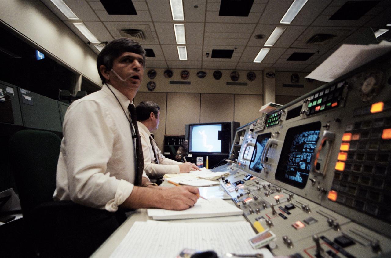 51L-S-002 (28 Jan. 1986) --- Flight directors Jay H. Greene (foreground) and Alan L. (Lee) Briscoe study data on monitors at their consoles in the flight control room (FCR) of the Johnson Space Center's Mission Control Center. The photo was made just moments after the announcement came that Challenger's launch phase was not nominal. Photo credit: NASA
