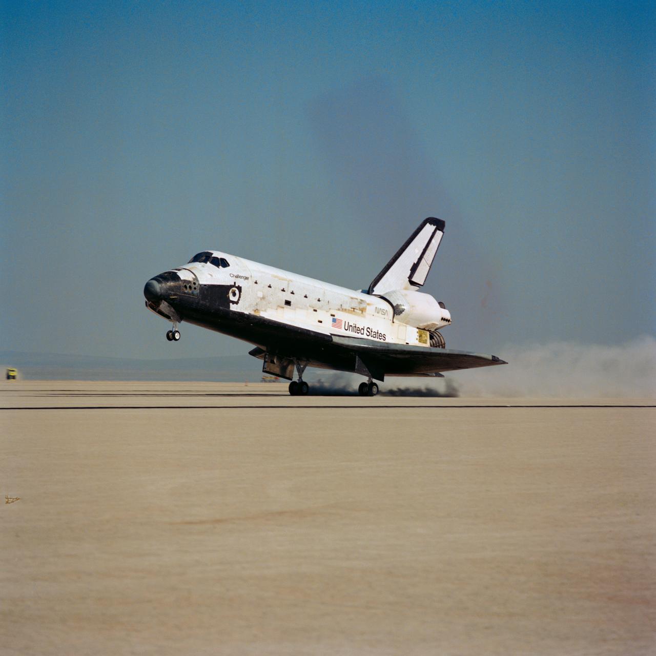 Shuttle Challenger lands on Runway 17 at Edwards at end of 51-B mission. The photo is a rear view of the shuttle landing gear touching the runway, with clouds of dirt trailing behind it. The nose gear is still in the air (071); Side view of the Challenger landing gear touching the runway (072).