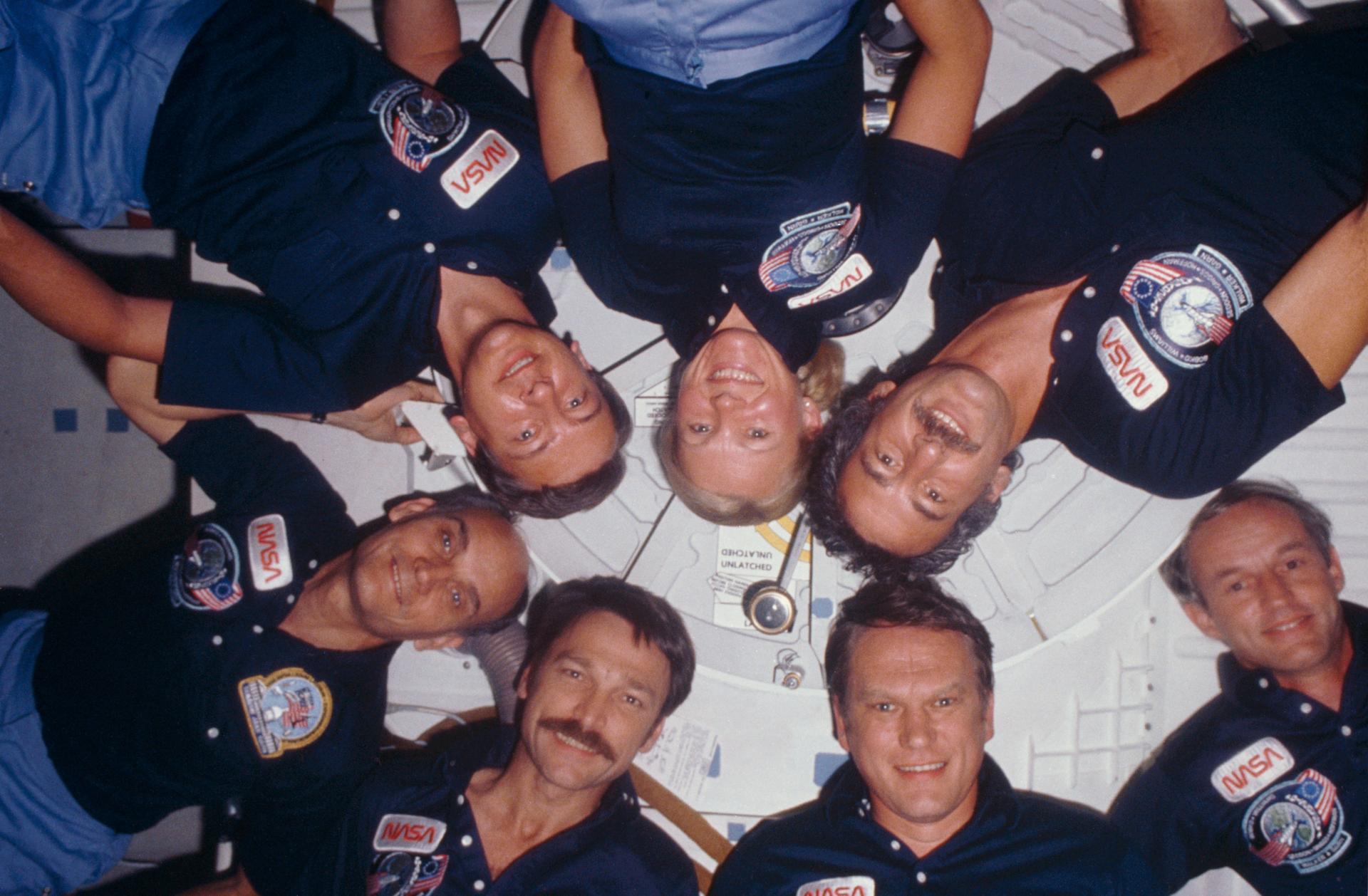 The 7 members of the STS-51D mission pose for a group photo during their flight.