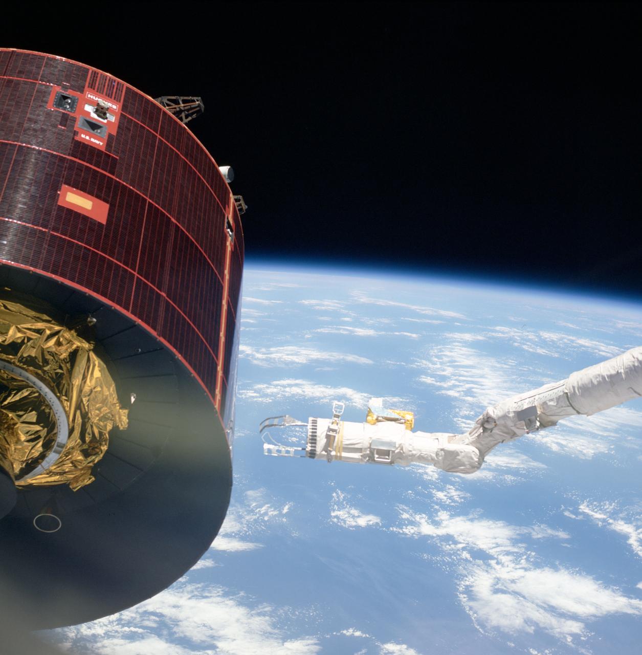 51D-44-046 (17 April 1985) --- The Space Shuttle Discovery's Remote Manipulator System (RMS) arm and two specially designed extensions move toward the troubled Syncom-IV (LEASAT) communications satellite during a station keeping mode of the two spacecraft in Earth orbit.  Inside the Shuttle's cabin, astronaut Rhea Seddon, 51D mission specialist, controlled the Canadian-built arm in an attempt to move an external lever on the satellite.  Crewmembers learned of the satellite's problems shortly after it was deployed from the cargo bay on April 13, 1985.  The arm achieved physical contact with the lever as planned.  However, the satellite did not respond to the contact as hoped.  A 70mm handheld Hassellblad camera, aimed through Discovery's windows, recorded this frame -- one of the first to be released to news media following return of the seven-member crew on April 17, 1985.