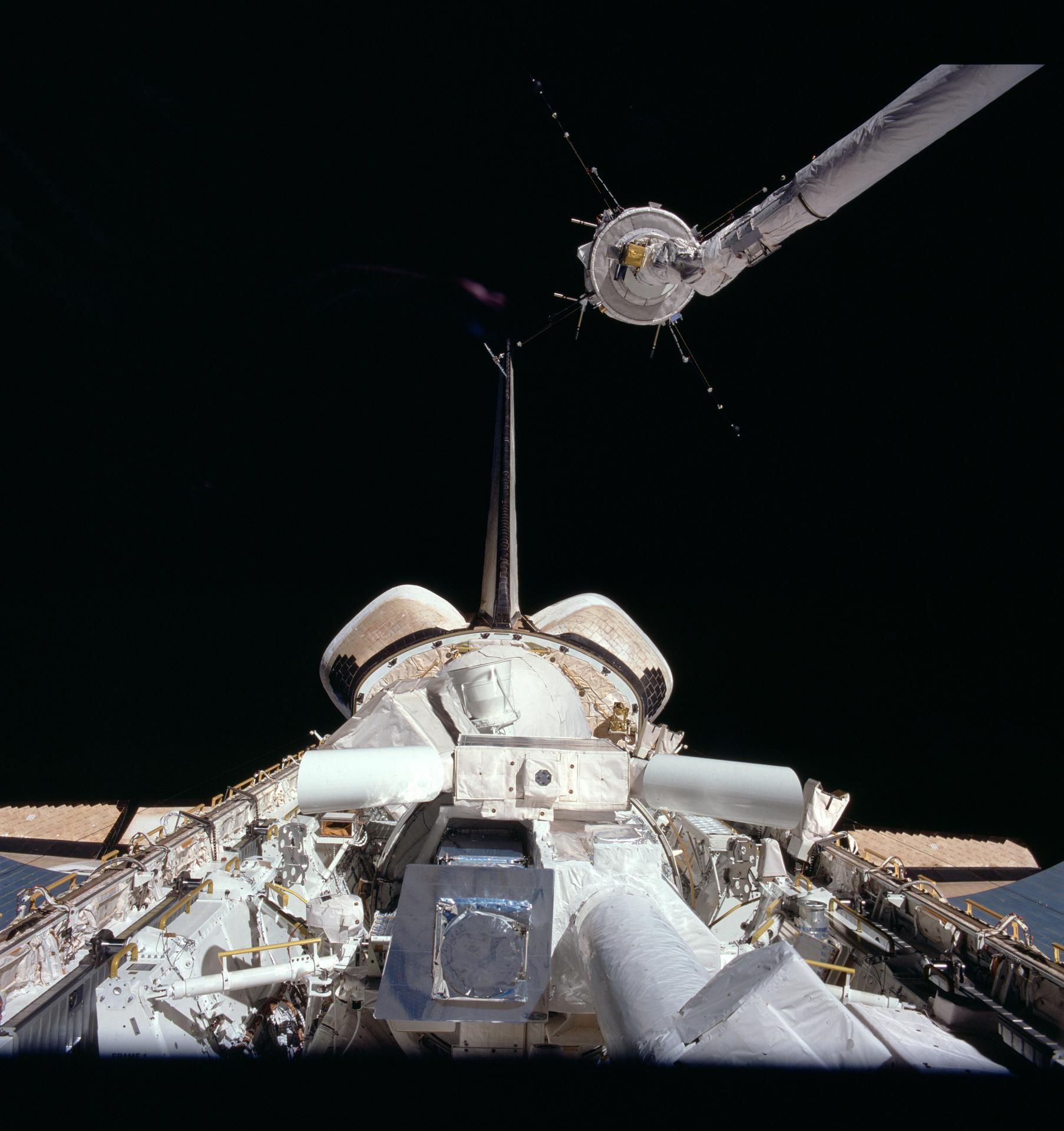 Challenger's remote manipulator system arm grasps one of the experiments in Challenger's payload bay during the STS-51F mission