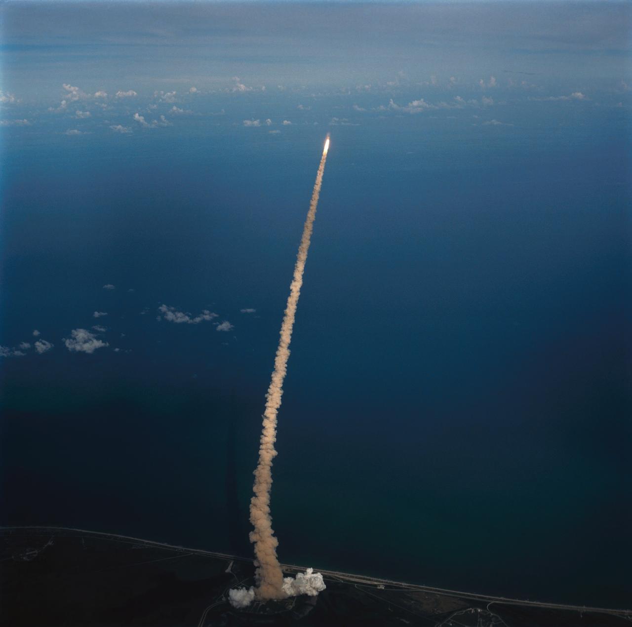 51F-S-038 (29 July 1985) ---An air-to-air view of the Space Shuttle orbiter Challenger, its two solid rocket boosters and external fuel tank moments after launch from Pad 39A at Kennedy Space Center (KSC).  Astronaut John W. Young, veteran of two Shuttle flights and four other NASA missions, took the photograph with a handheld camera while piloting the Shuttle training aircraft.  Launch occured at 5:00:00:423 p.m. (EDT), July 29, 1985.