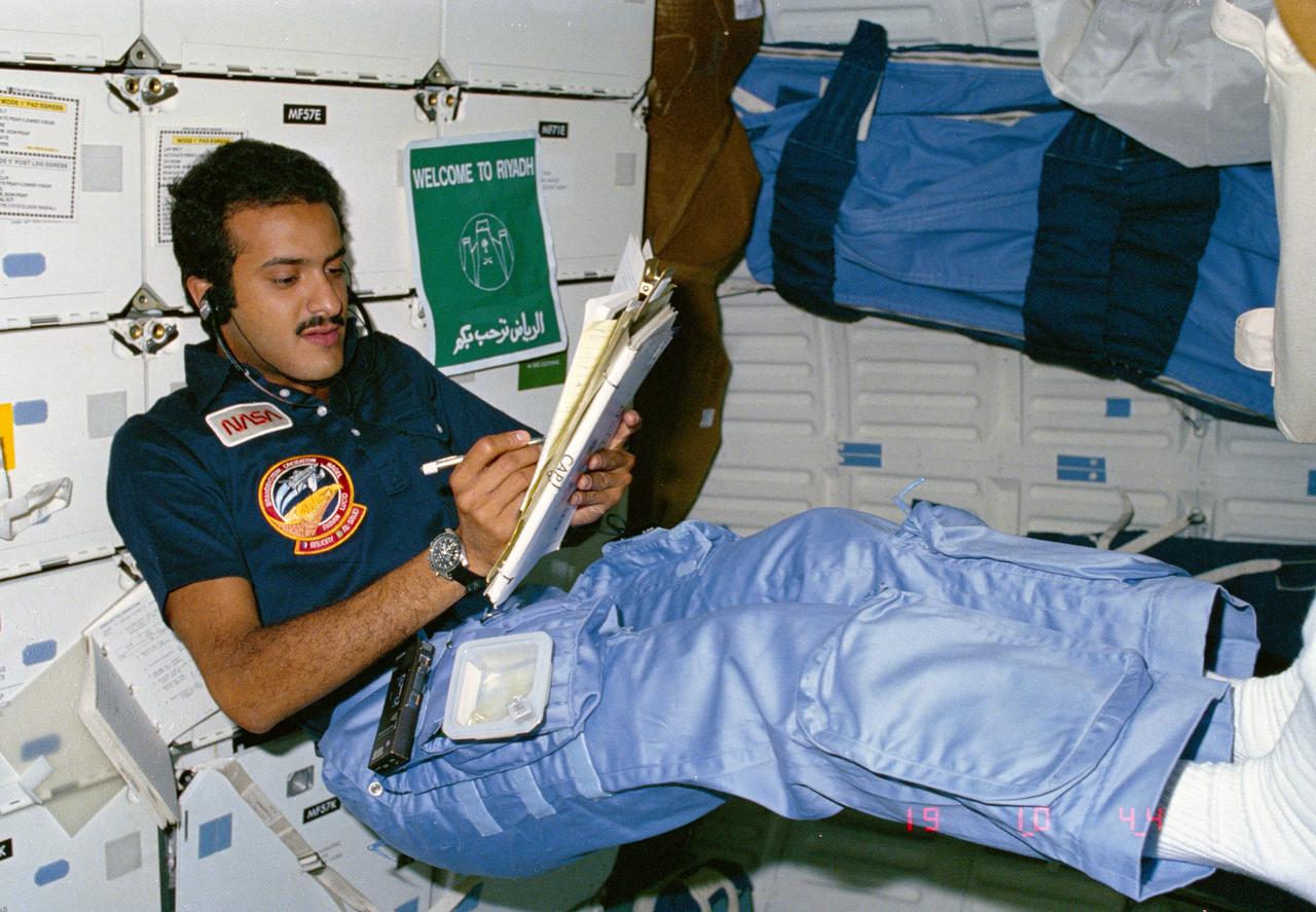 51G-04-010 (17 - 24 June 1985) --- Payload Specialist Sultan Salman Abdelize Al-Saud assumes a posture common to the weightlessness environment of space as he logs notes in Discovery?s middeck area.