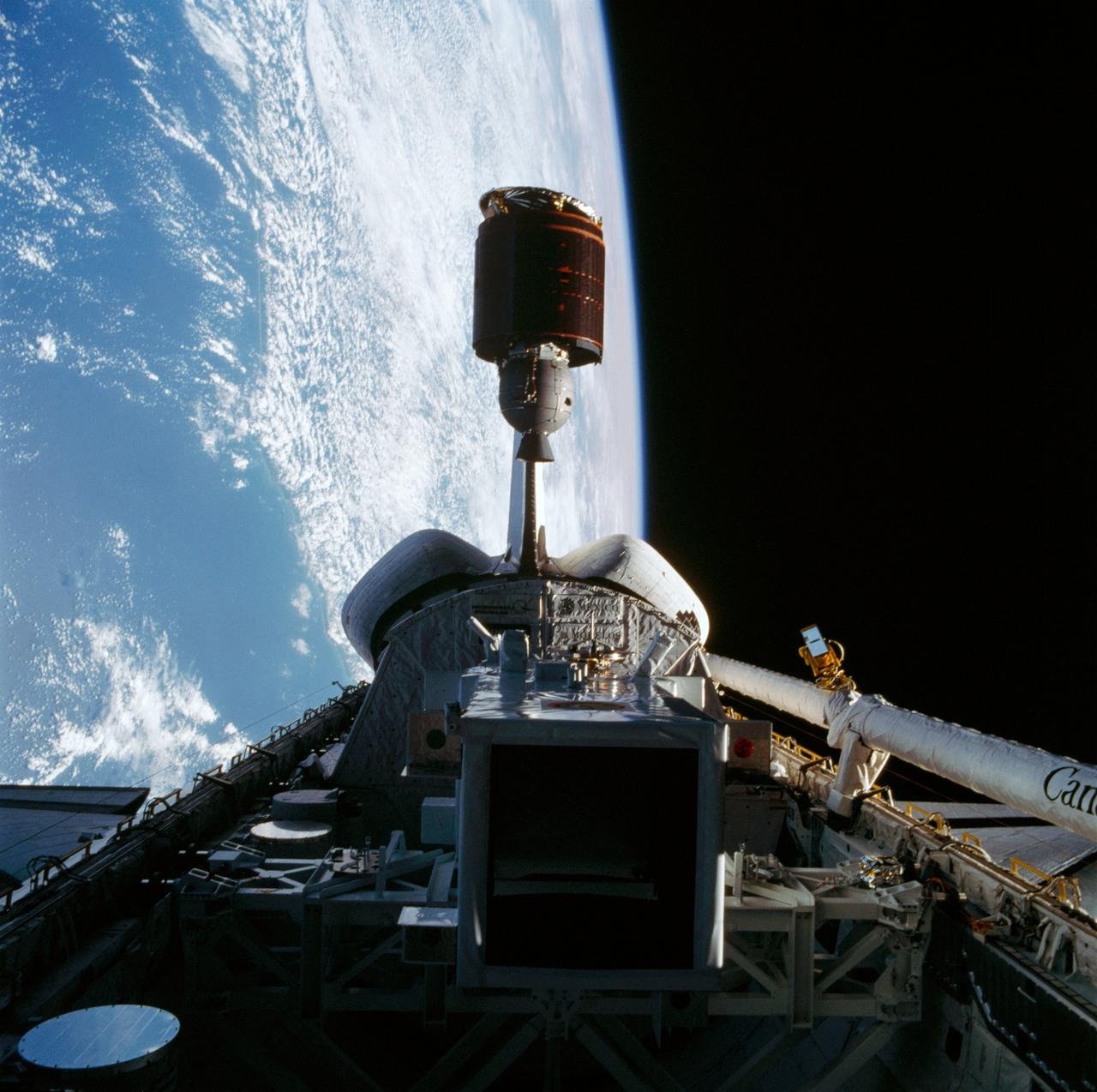 Telstar 3-D communications satellite deploying from Discovery's payload bay. Cloudy Earth's surface can be seen to the left of the frame.