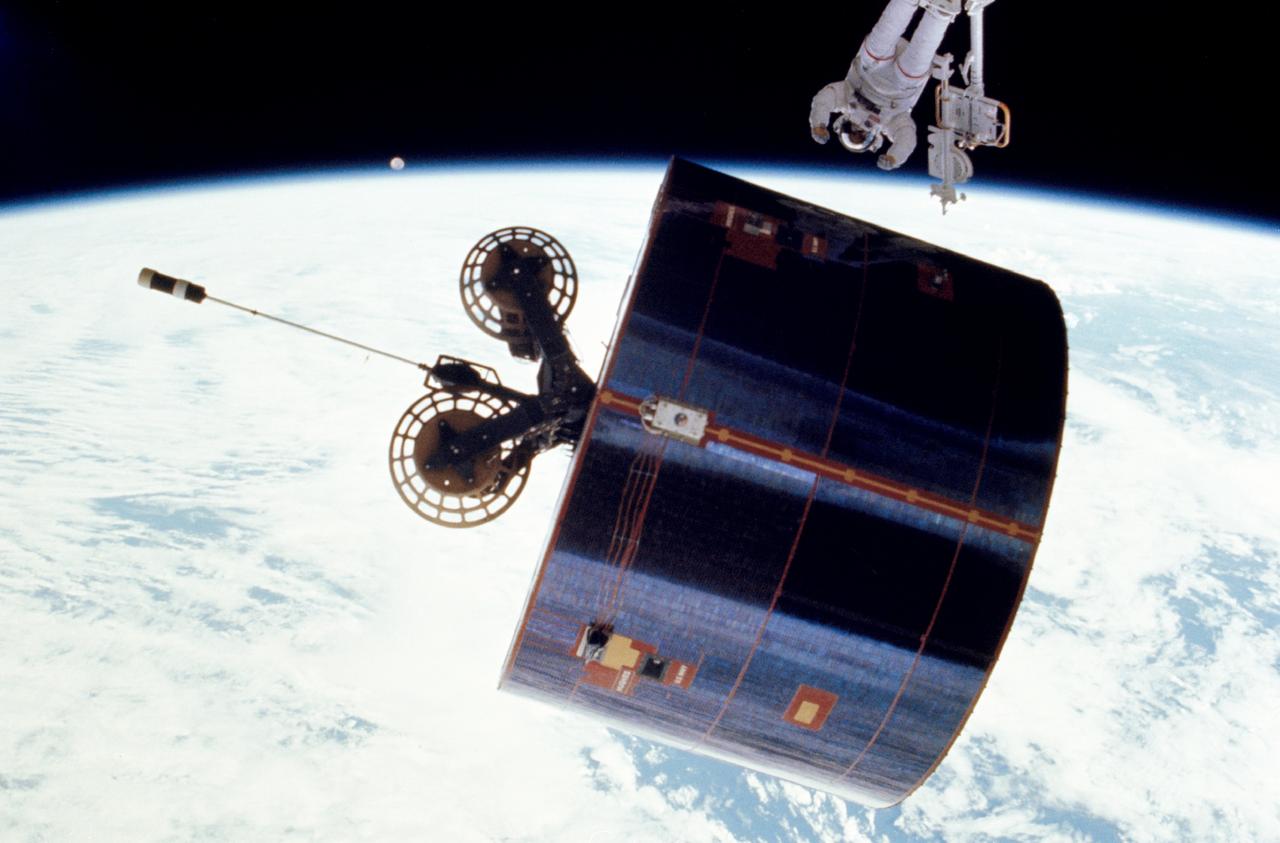 51I-102-033 (31 August - 1 September 1985) --- This is one of a series of six photographs released by NASA covering the extravehicular activity (EVA) of astronauts James D. van Hoften and William F. Fisher, who helped to capture, repair and release the previously errant Syncom IV-3 communications satellite.  Here, Dr. van Hoften has just given a shove to the the Syncom. (For orientation, moon should be in lower right quadrant).