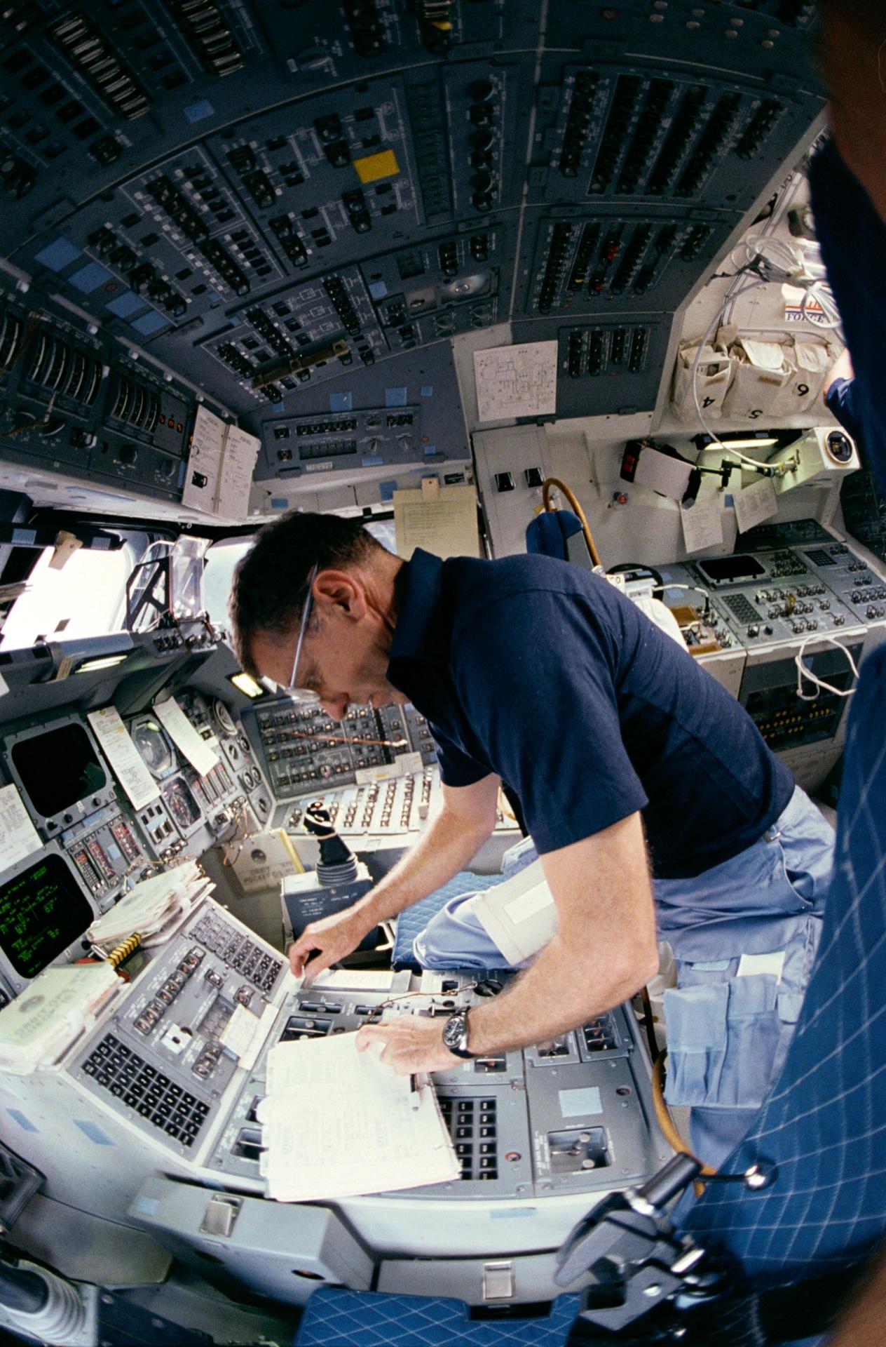 STS-51I commander Joe Engle works at the controls of space shuttle Discovery