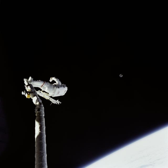 NASA image: Astronaut James van Hoften on RMS tracking Syncom IV-3 after deployment