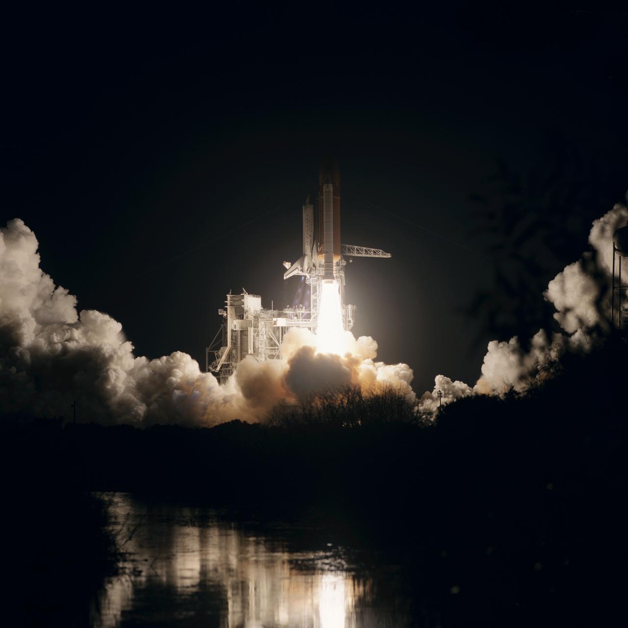 Launch of the Shuttle Discovery and begining of STS 51-I mission. View of the pre-dawn launch shows a reflection of the ignition in the river across from the launch complex (223); Clouds of smoke from the launch reflect the light of the ignited engines in this view of the pre-dawn launch (224).