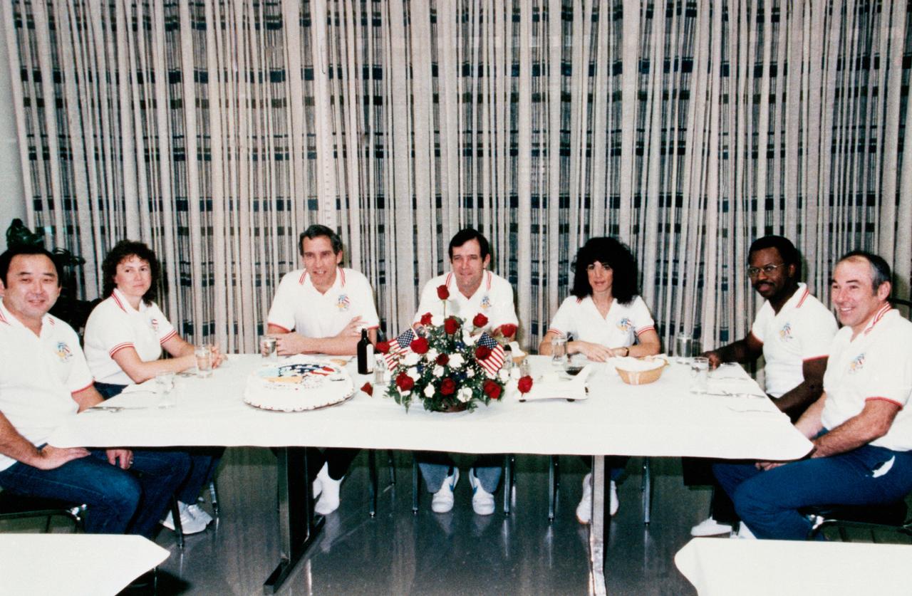 51L-S-029 (28 Jan. 1986) --- Crew members of the STS-51L mission are seated for breakfast launch morning in the Operations and Checkout Building prior to liftoff of the space shuttle Challenger scheduled for 9:38 a.m. The launch was scheduled for Jan. 27, 1986, but was delayed 24 hours due to unacceptable cross winds. Crew members left to right are Ellison S. Onizuka, mission specialist; Sharon Christa McAuliffe, payload specialist; Michael J. Smith, pilot; Francis R. Scobee, commander; Judith A. Resnik and Dr. Ronald E. McNair, mission specialists; and Gregory D. Jarvis, payload specialist. EDITOR?S NOTE: The STS-51L crew members lost their lives in the space shuttle Challenger accident moments after launch on Jan. 28, 1986 from the Kennedy Space Center (KSC).  Photo credit: NASA
