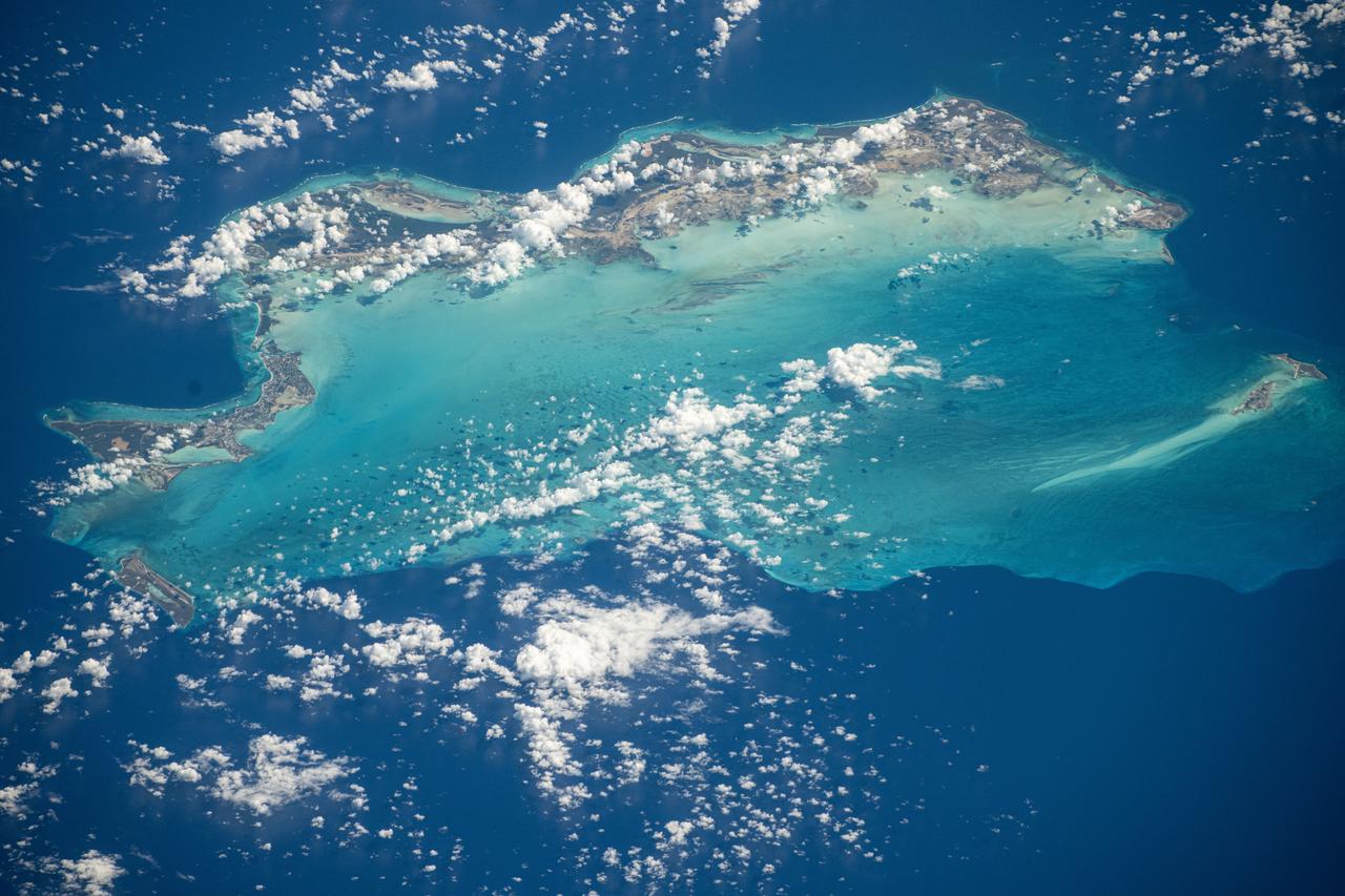 iss072e012016 (Oct. 3, 2024) -- The vibrant turquoise water surrounding the Turks and Caicos Islands contrasts against the deep blue of the Atlantic Ocean in this image taken from the International Space Station as it orbited 256 miles above.