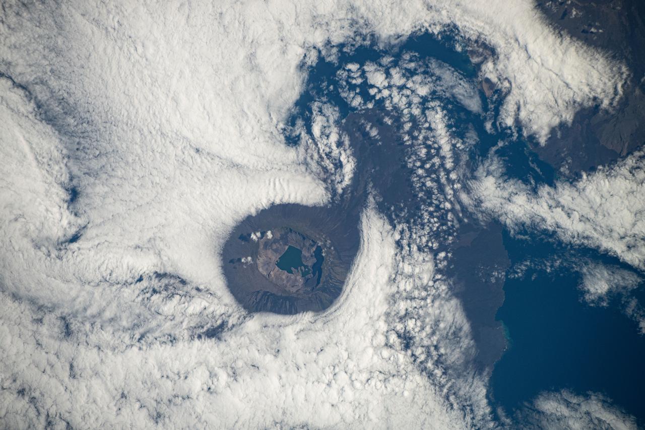iss072e011909 (Oct. 3, 2024) -- Situated in the Galapagos is Fernandina Island. Pictured here is Fernandina's caldera, which stretches about 4 miles ( 6.5 kilometers) wide, with a sheet of clouds forming around it. As the International Space Station orbited 257 miles above, NASA astronaut Don Pettit captured this image.