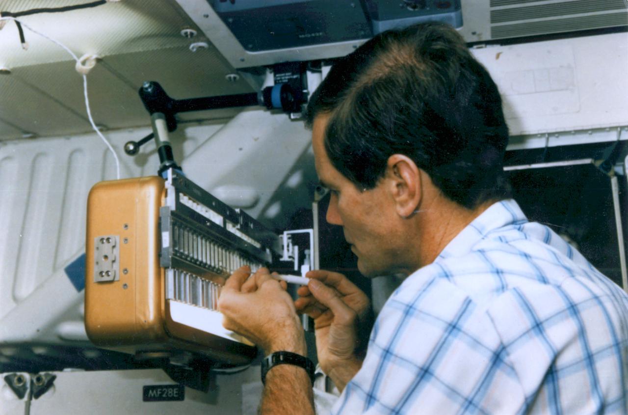 Crew member practices injecting seed crystals into hand-held Protein Crystallization Apparatus for Microgravity (PCAM).