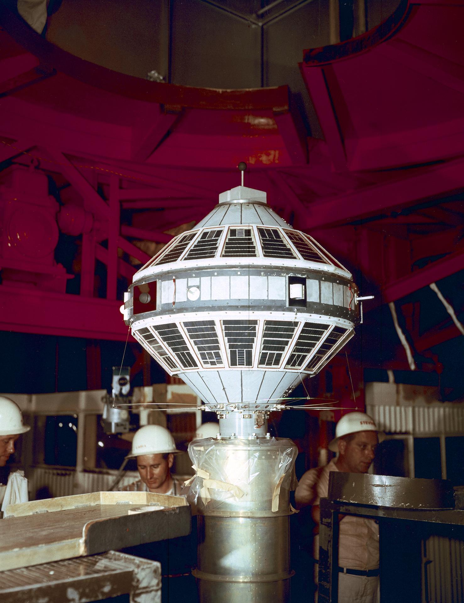 Workers installing the Explorer VII satellite on the Juno II booster.