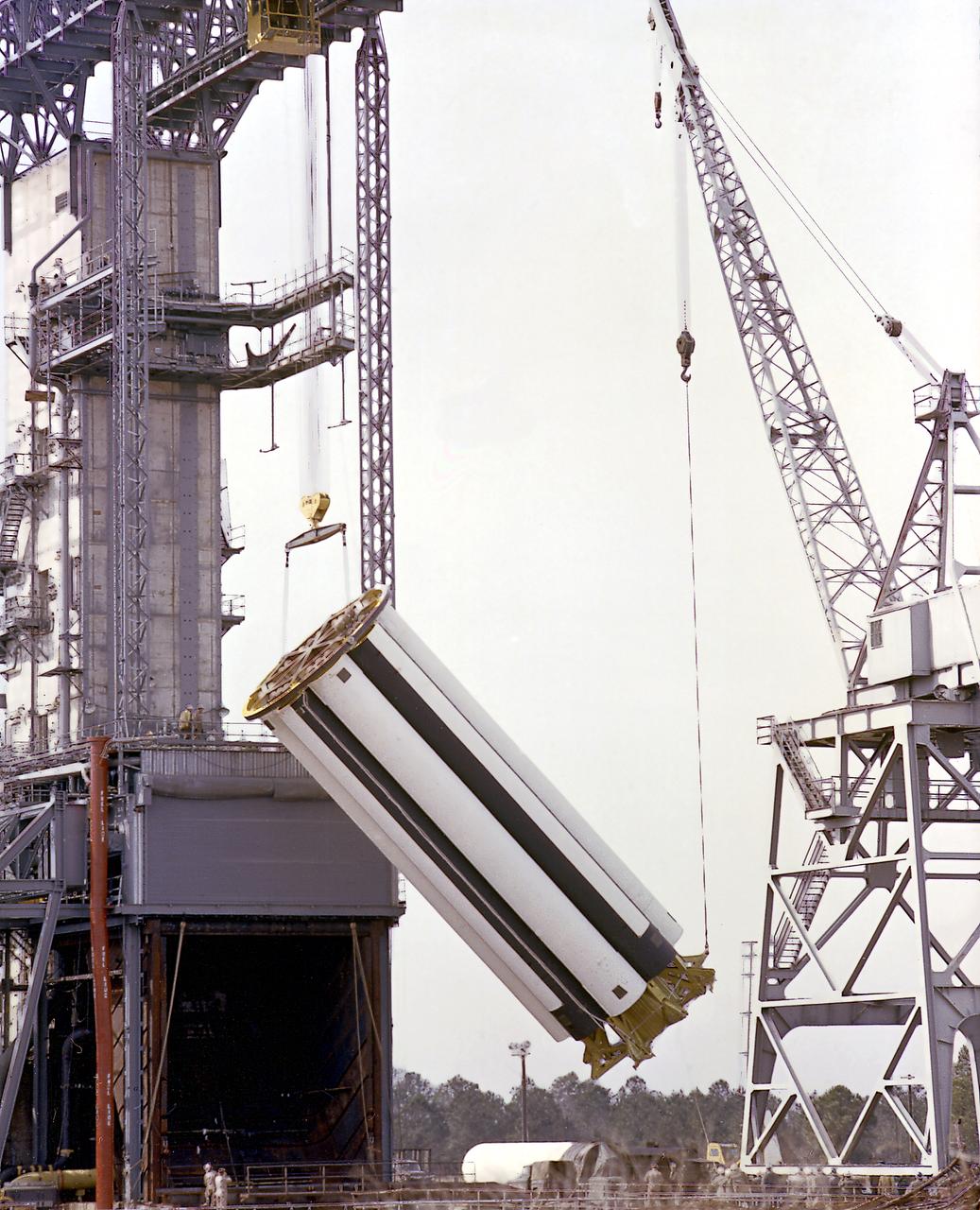 The Saturn Project was approved on January 18, 1960 as a program of the highest national priority. The formal test program, to prove out the clustered-booster concept, was well underway at Redstone Arsenal. This photograph depicts a mockup of the Saturn booster (S-I stage) being installed in the Army Ballistic Missile Agency (ABMA) test stand, on January 19, 1960, to check mating of the booster and stand and servicing methods.
