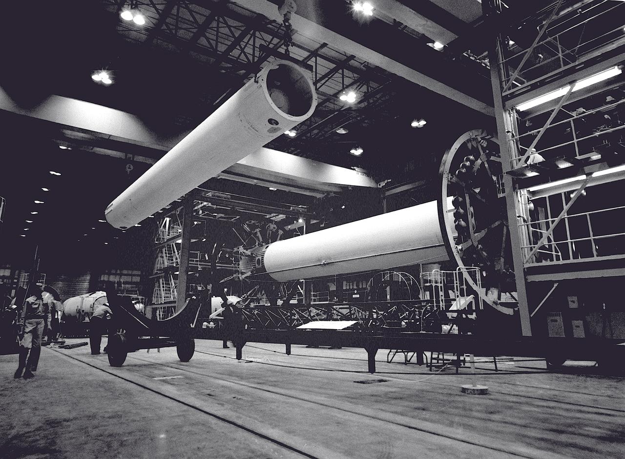 The Saturn I S-I stage is being assembled in the fabrication and engineering laboratory at the Marshall Space Flight Center. The two end spider beams are cornected to the central 267-centimeter diameter liquid-oxygen (LOX) tank. The first of the eight 178-centimeter outer tanks, used alternately for liquid oxygen and kerosene, is being lifted into position.