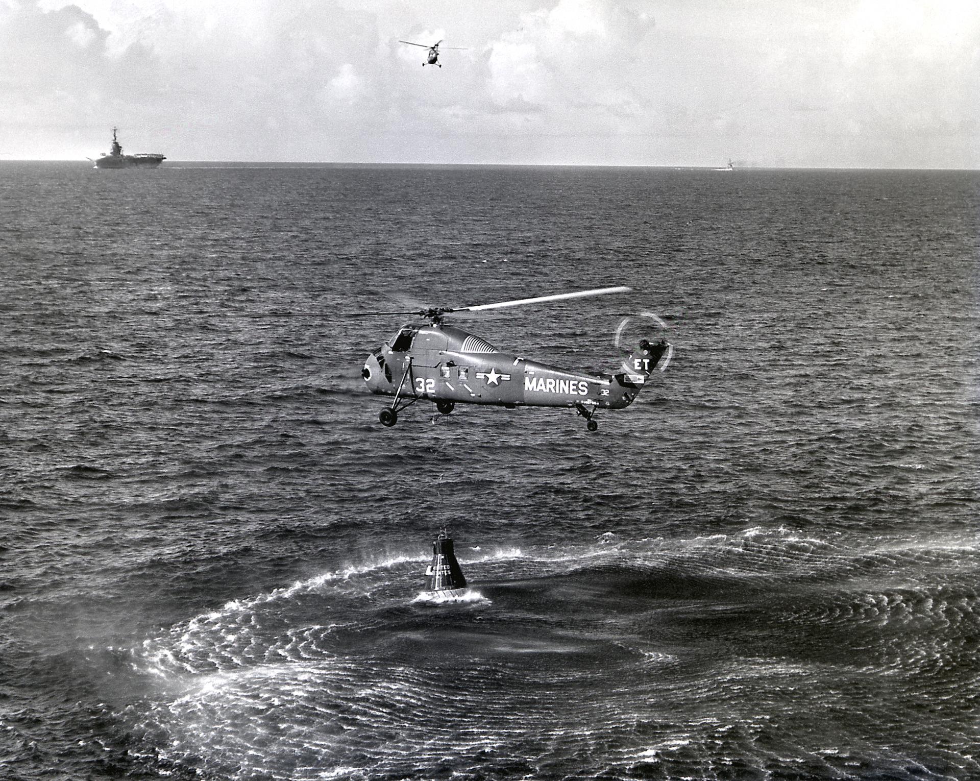 A helicopter hovers over the ocean in attempt to retrieve the Liberty Bell 7 capsule