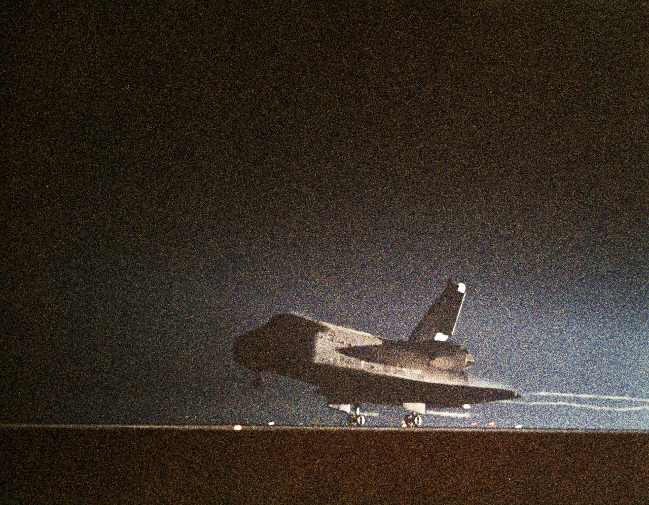 61C-S-050 (18 Jan 1986) --- This NASA photo records the night landing of space shuttle Columbia at Edwards Air Force Base and end of the STS 61-C mission. View is of the shuttle's main landing gear touching down, with streams of light trailing behind the orbiter. Photo credit: NASA