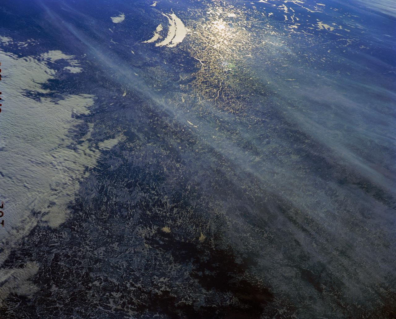 61A-200-152 (30 Oct-5 Nov 1985) --- Sun glints on the small and very numerous glacial lakes of the Canadian Shield of Quebec. This is an area of very ancient pre-Cambrian rock, which uplifted when the weight of the Pleistocene glaciers was removed. The double crescent lake is Lake Mistassini, some 400 miles north of Montreal.