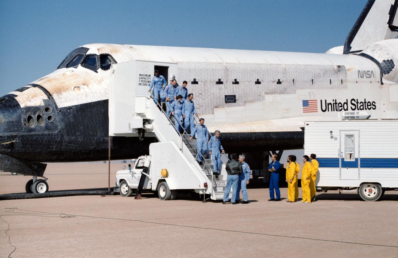 61A-S-140 (6 Nov 1985) --- The record-setting eight crewmembers for STS 61-A file from their "home"   for the past week at the completion of a successful Spacelab D-1 mission.  Astronaut Henry W. Hartsfield Jr., mission commander, shakes hands with George W. S. Abbey, director of flight crew operations at JSC.  Other crewmembers, from left to right, are Astronauts Guion S. Bluford Jr., James F. Buchli, Steven R. Nagel and Bonnie J. Dunbar; and Payload Specialists Wubbo J. Ockels, Ernst Messerschmid and Reinhard Furrer.  The Challenger came to a complete stop at 9:45:39 a.m. (PST).