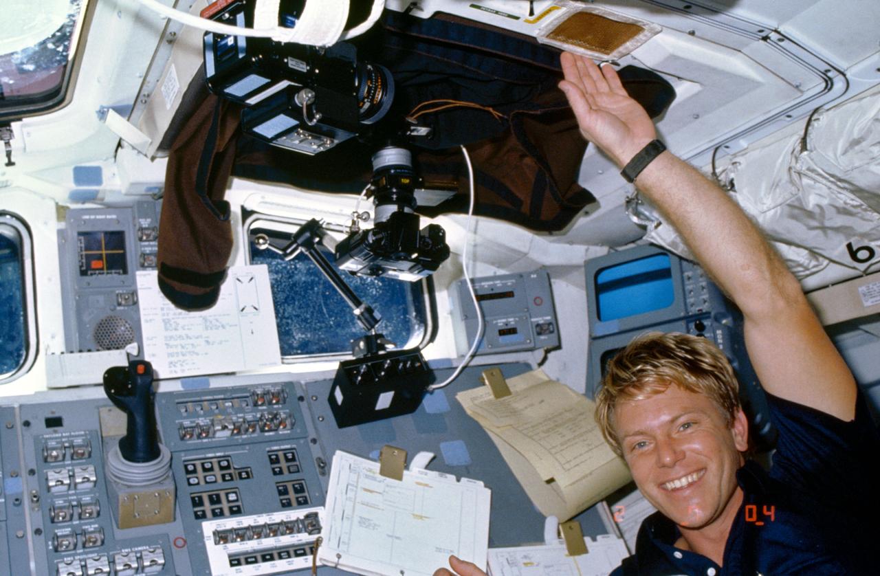 61C-05-026 (14 Jan. 1986) --- Astronaut George D. Nelson smiles for a fellow crew man's 35mm camera exposure while participating in the Comet Halley active monitoring program (CHAMP). Camera equipment and a protective shroud used to eliminate all cabin light interference surround the mission specialist. This is the first of three 1986 missions which are scheduled to monitor the rare visit by the comet. The principal investigators for CHAMP are S. Alan Stern of the Laboratory for Atmospheric and Space Physics at the University of Colorado; and Dr. Stephen Mende of Lockheed Palo Alto Research Laboratory.