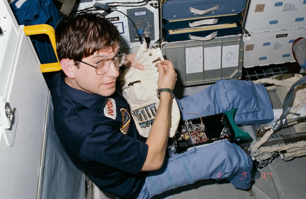 61C-05-035 (12-17 Jan 1986) --- Robert J. Cenker, 61-C payload specialist representing RCA, returns   a tiny tool to its stowage position after adjusting the inner workings of a device used in one of a number of detailed supplementary objective (DSO) studies for NASA's Space Biomedical Research Institute.  The device is a pair of ocular counter-rolling goggles used by U.S. Rep. Bill Nelson (D., Florida), 61-C's other   payload specialist aboard the Columbia for this five-day flight.