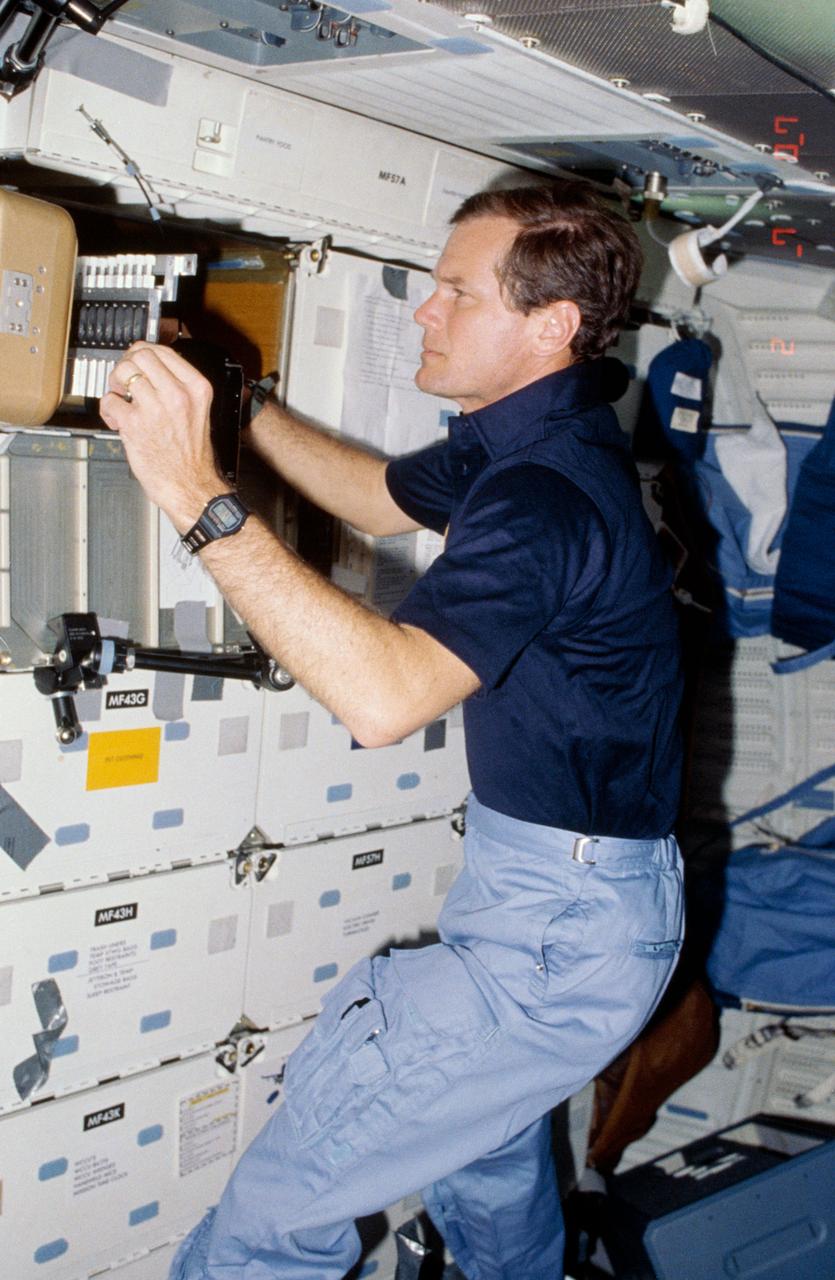 61C-05-036 (12-18 Jan. 1986) --- U.S. Representative Bill Nelson (Democrat - Florida), STS-61C payload specialist, prepares to photograph individual samples in the Handheld Protein Crystal Growth Experiment (HPCG) on Columbia's middeck. The operations involve the use of four pieces of equipment to attempt the growth of 60 different types of crystals -- 12 by means of dialysis and 48 via the vapor diffusion method. The photo was used by members of the STS-61C crew at their Jan. 23, 1986, Post-Flight Press Conference.