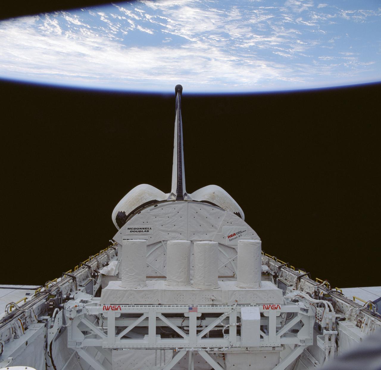 61C-39-002 (12-17 Jan 1986) --- This view of the cargo bay of the Earth-orbiting Space Shuttle Columbia reveals some of the STS 61-C mission payloads.  The materials science laboratory (MSL-2), sponsored by the Marshall Space Flight Center  (MSFC), is in the foreground.  A small portion of  the first Hitchhiker payload, sponsored by the Goddard Space Flight Center (GSFC), is in the immediate foreground, mounted to the spacecraft's starboard side.  The closed sun shield for the now-vacated RCA SATCOM K-1 communications satellite is behind the MSL.  Completely out of view, behind the shield, are 13 getaway specials in canisters.  Clouds over ocean and the blackness of space share the backdrop for the 70mm camera's frame.