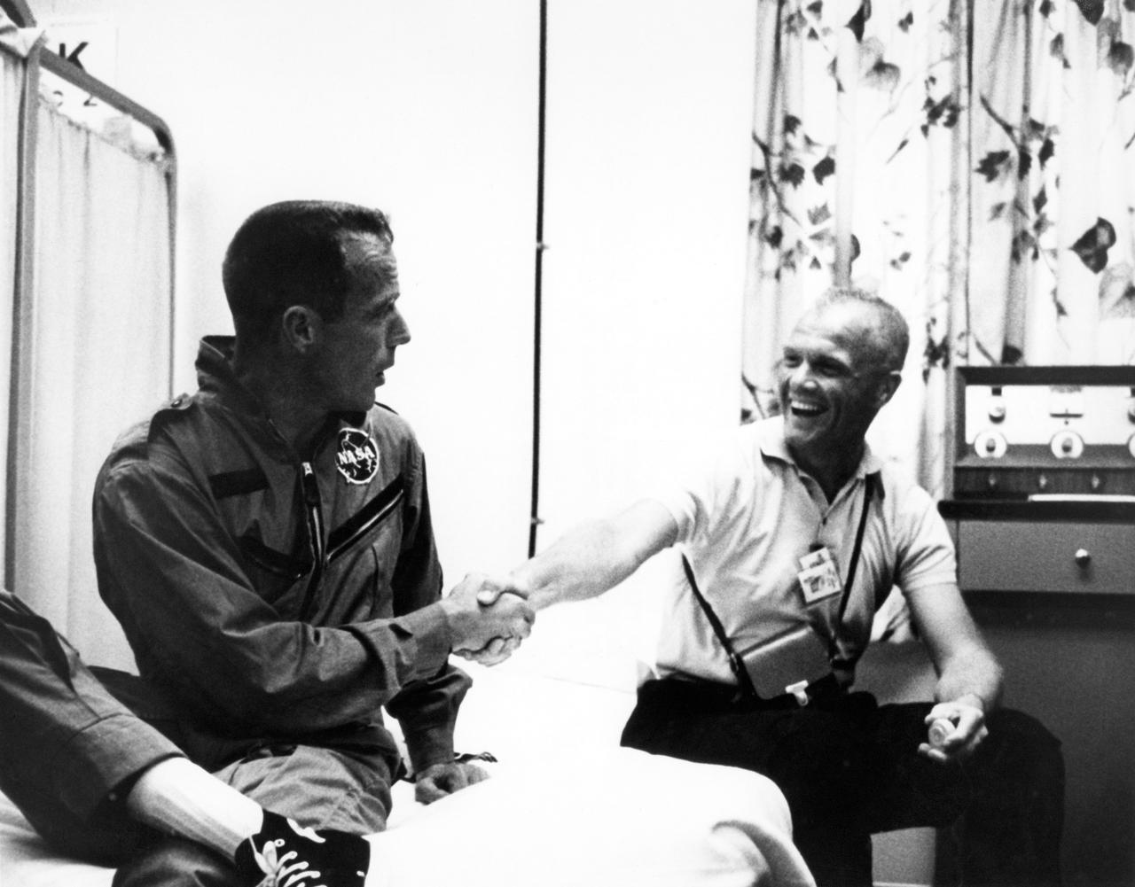 62-MA7-169 (1962) --- John Glenn congratulates Scott Carpenter (left) on his three-orbit mission aboard the Aurora 7 spacecraft. Photo credit: NASA