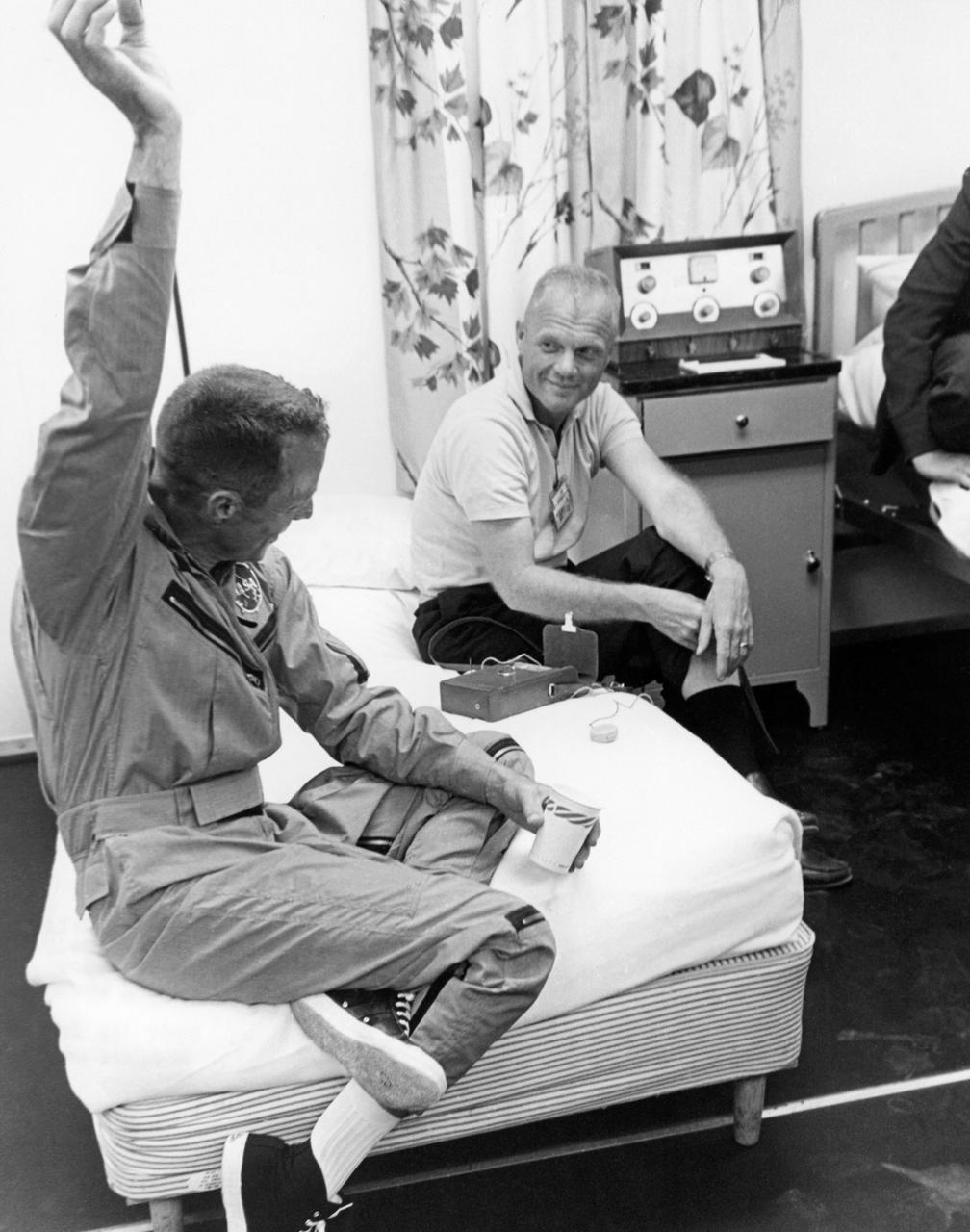 CAPE CANAVERAL, Fla. -- Scott Carpenter demonstrates a point to John Glenn while relaxing after his three-orbit MA-7 spaceflight.   Photo credit: NASA