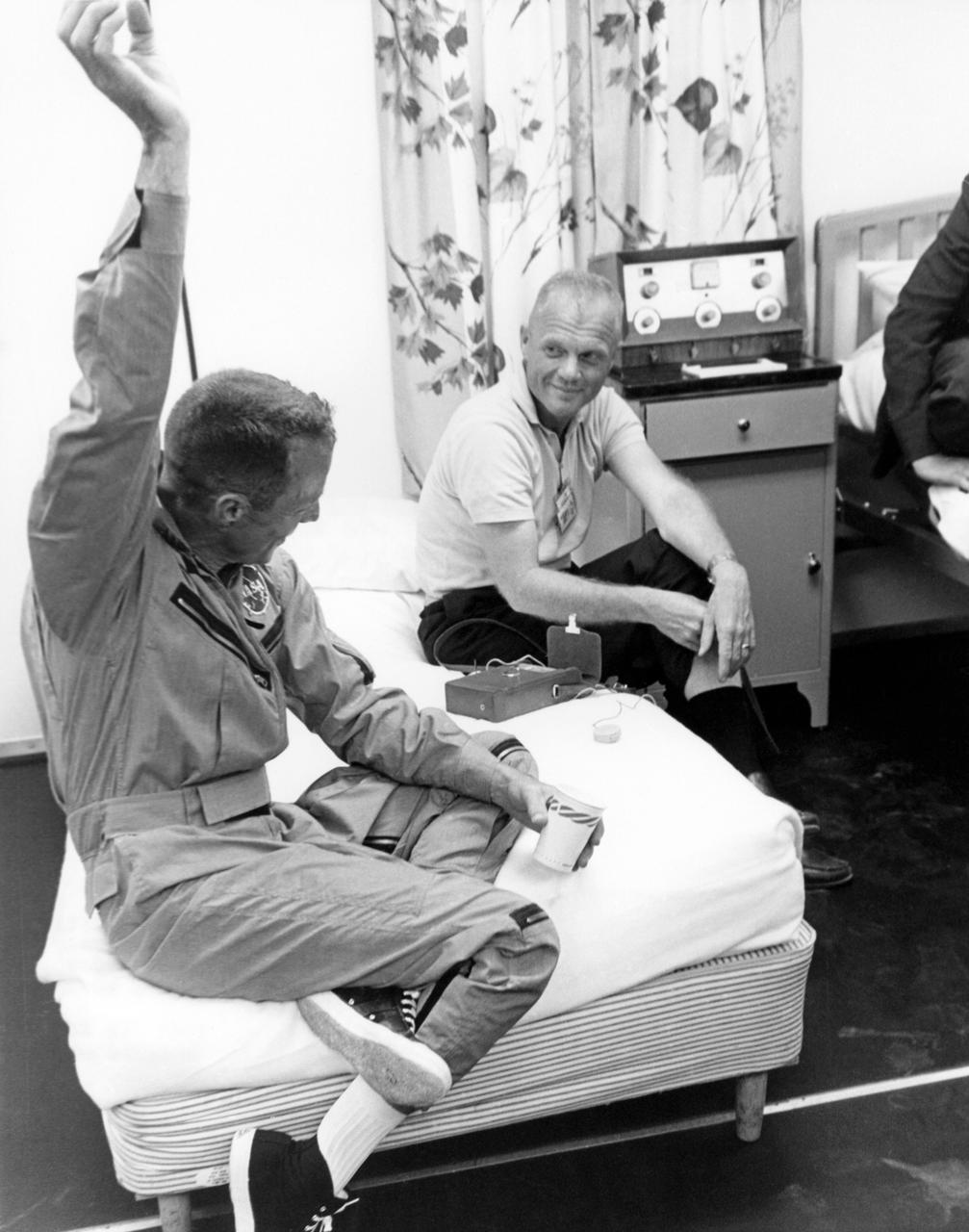 62-MA7-123 (1962) --- Scott Carpenter (foreground) demonstrates a point to John Glenn while relaxing after his three-orbit MA-7 spaceflight. Photo credit: NASA