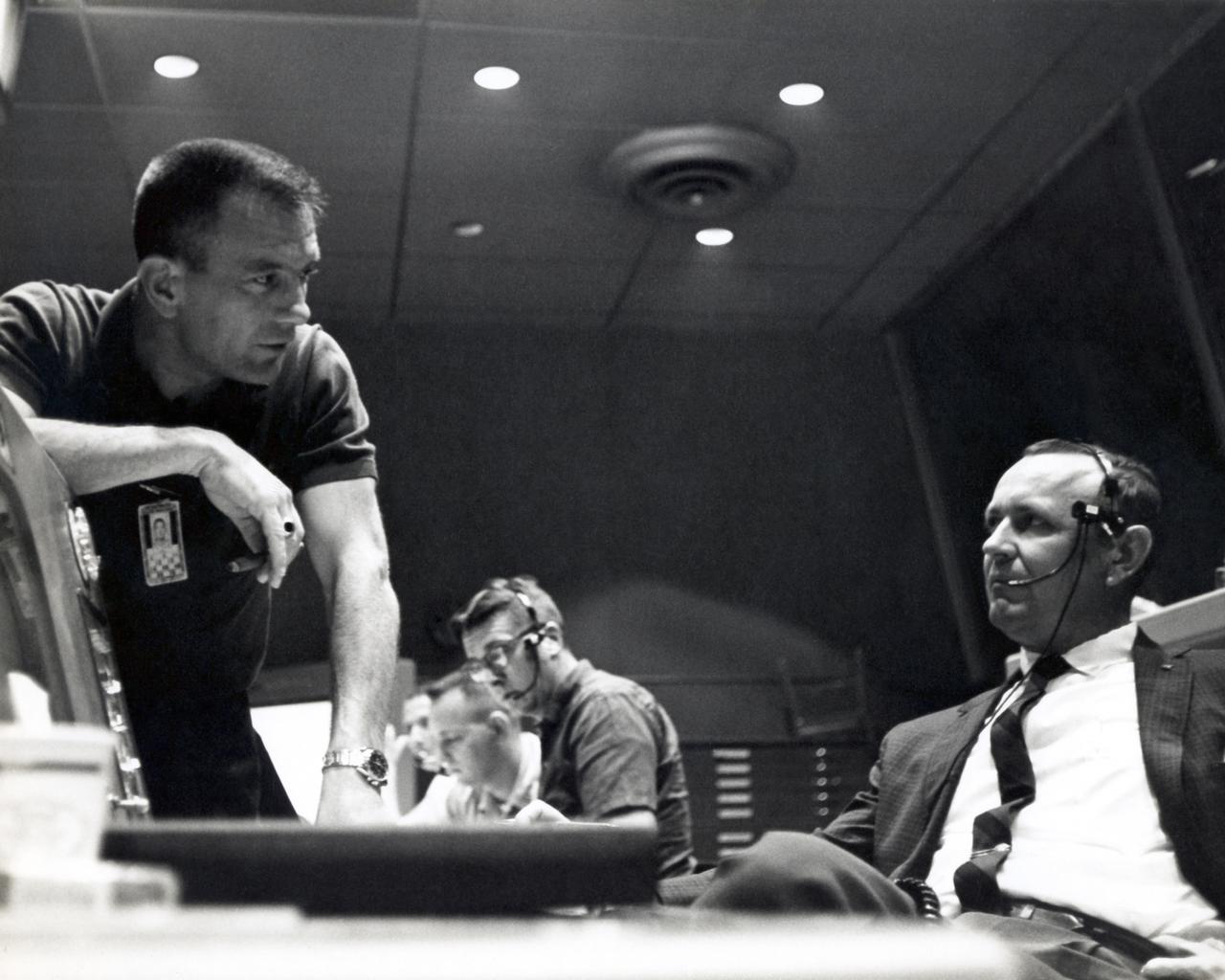 CAPE CANAVERAL, Fla. - Inside Mercury Mission Control, astronaut Deke Slayton left discusses a point with Christopher Kraft, Mercury's flight director, during preparations for astronaut Gordon Cooper's Faith 7 launch, which took place on May 15, 1963.     The Mercury Mission Control Center in Florida played a key role in the United States' early spaceflight program. Located at Cape Canaveral Air Force Station, the original part of the building was constructed between 1956 and 1958, with additions in 1959 and 1963. The facility officially was transferred to NASA on Dec. 26, 1963, and served as mission control during all the Project Mercury missions, as well as the first three flights of the Gemini Program, when it was renamed Mission Control Center. With its operational days behind, on June 1, 1967, the Mission Control Center became a stop on the public tour of NASA facilities until the mid-90s. In 1999, much of the equipment and furnishings from the Flight Control Area were moved to the Kennedy Space Center Visitor Complex where they became part of the exhibit there. The building was demolished in spring 2010. Photo credit: NASA