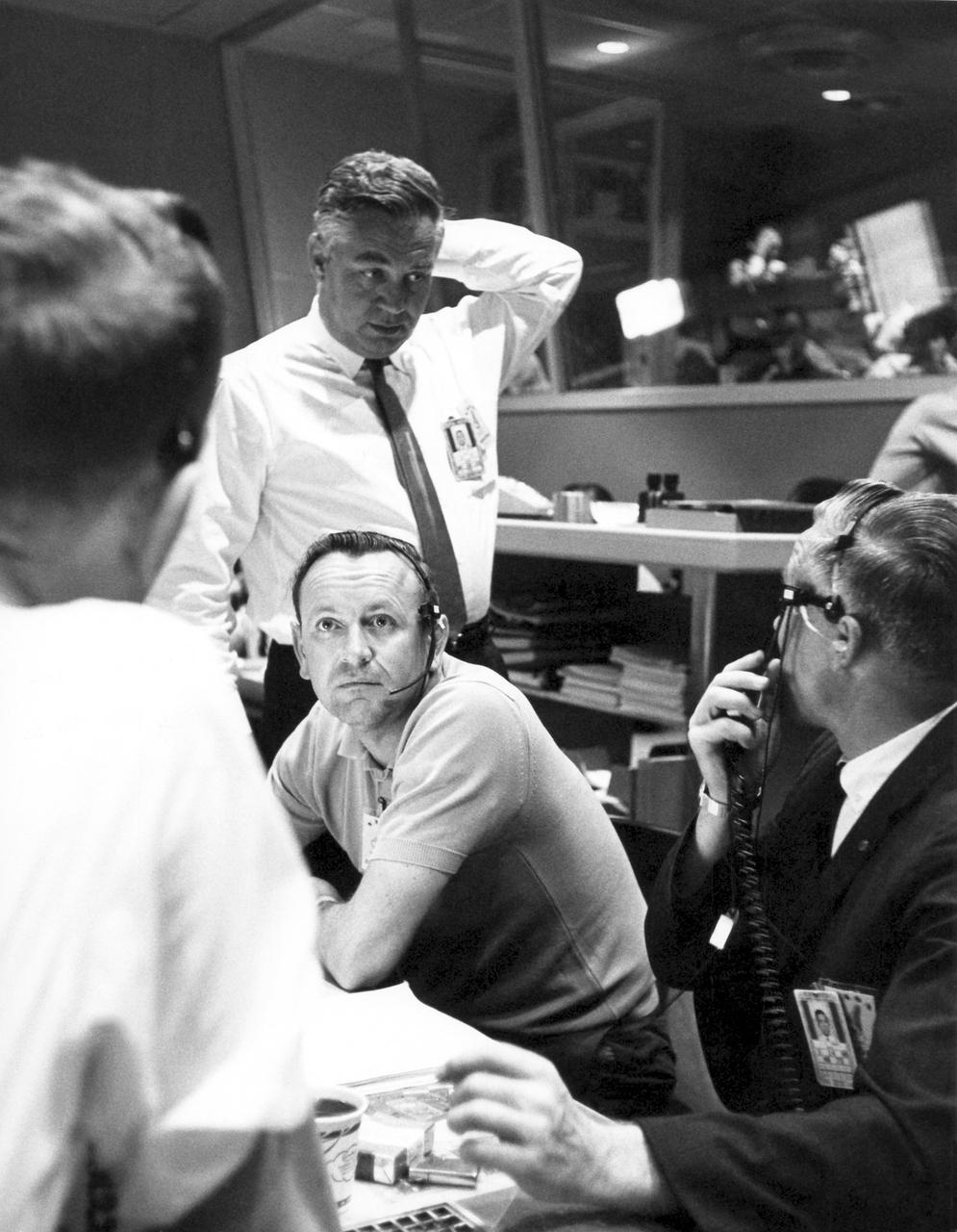 CAPE CANAVERAL, Fla. - Inside Mercury Mission Control, Walter C. Williams standing, associate director for Project Mercury operations, and Christopher Kraft seated, left, flight director, work in flight control as the decision is made to have Mercury astronaut Gordon Cooper aboard his spacecraft, Faith 7, go the full 22 orbits. The launch took place on May 15, 1963.     The Mercury Mission Control Center in Florida played a key role in the United States' early spaceflight program. Located at Cape Canaveral Air Force Station, the original part of the building was constructed between 1956 and 1958, with additions in 1959 and 1963. The facility officially was transferred to NASA on Dec. 26, 1963, and served as mission control during all the Project Mercury missions, as well as the first three flights of the Gemini Program, when it was renamed Mission Control Center. With its operational days behind, on June 1, 1967, the Mission Control Center became a stop on the public tour of NASA facilities until the mid-90s. In 1999, much of the equipment and furnishings from the Flight Control Area were moved to the Kennedy Space Center Visitor Complex where they became part of the exhibit there. The building was demolished in spring 2010. Photo credit: NASA