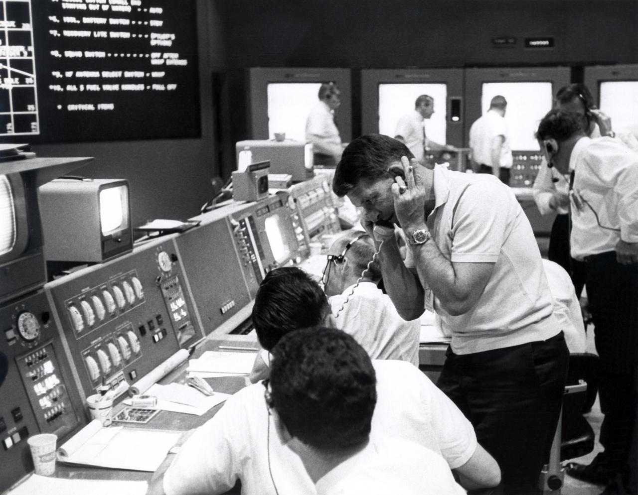 CAPE CANAVERAL, Fla. - Inside Mercury Mission Control, astronaut Wally Schirra, capsule communicator, or capcom for the Mercury-Atlas 9 mission, talks to Trudy Cooper, wife of astronaut Gordon Cooper, on May 16, 1963, to inform her that he had just been recovered by the USS Kearsarge after his 22-orbit flight.     The Mercury Mission Control Center in Florida played a key role in the United States' early spaceflight program. Located at Cape Canaveral Air Force Station, the original part of the building was constructed between 1956 and 1958, with additions in 1959 and 1963. The facility officially was transferred to NASA on Dec. 26, 1963, and served as mission control during all the Project Mercury missions, as well as the first three flights of the Gemini Program, when it was renamed Mission Control Center. With its operational days behind, on June 1, 1967, the Mission Control Center became a stop on the public tour of NASA facilities until the mid-90s. In 1999, much of the equipment and furnishings from the Flight Control Area were moved to the Kennedy Space Center Visitor Complex where they became part of the exhibit there. The building was demolished in spring 2010. Photo credit: NASA