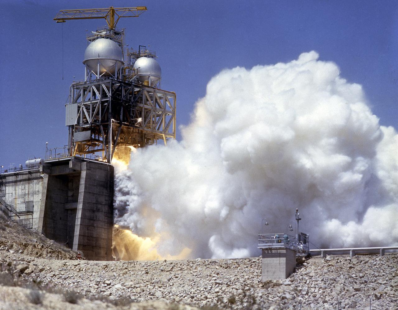 This photograph depicts the Rocketdyne static firing of the F-1 engine at the towering 76-meter Test Stand 1-C in Area 1-125 of the Edwards Air Force Base in California. The Saturn V S-IC (first) stage utilized five F-1 engines for its thrust. Each engine provided 1,500,000 pounds, for a combined thrust of 7,500,000 pounds with liquid oxygen and kerosene as its propellants. 