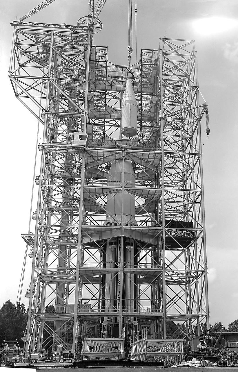 This image depicts the Saturn I launch vehicle placed in the dynamic test stand at the Marshall Space Flight Center (MSFC). A dummy booster was moved to the dynamic test stand early in June, and, for the first time, vertically mated with dummy S-I and S-IV stages. The assembled vehicle was readied for dynamic testing to investigate the integrity of the support structure.
