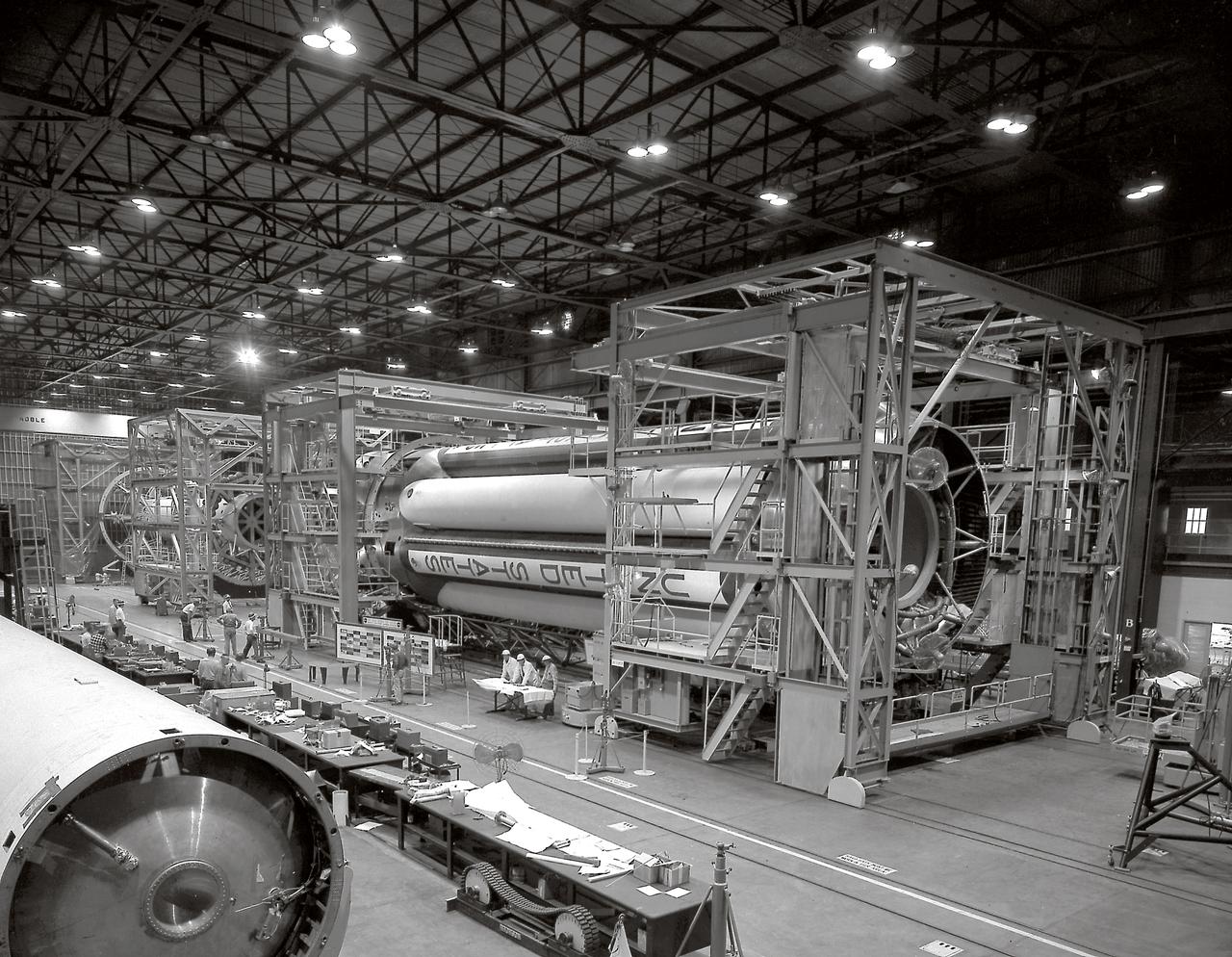 The S-I stages for the Saturn I (SA-1 at right and SA-2 at left) are being assembled at the Marshall Space Flight Center, building 4705. The Saturn I S-I stage had eight H-1 engines clustered, using liquid oxygen/kerosene-1 (LOX/RP-1) propellants capable of producing a total of 1,500,000 pounds of thrust.